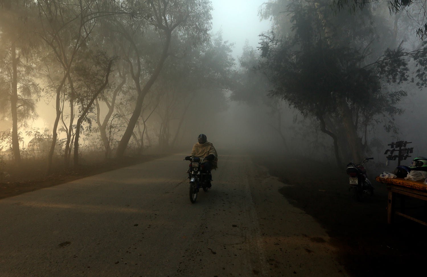  A motorcyclist drives as heavy fog reduces visibility, in Peshawar, Pakistan, Sunday, Jan. 1, 2023. (AP Photo/Muhammad Sajjad) 