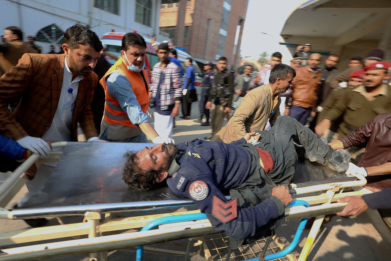  Workers and volunteers carry an injured victim of a suicide bombing upon arrival at a hospital in Peshawar, Pakistan, Monday, Jan. 30, 2023. (AP Photo/Muhammad Sajjad) 