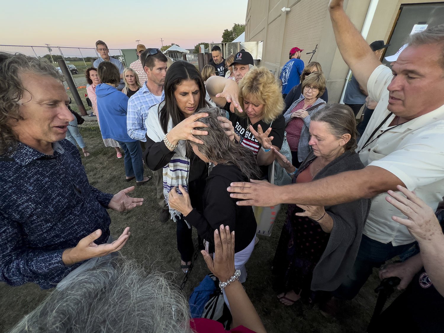  Amanda Grace of Ark of Grace Ministries and a group of people gather in prayer around a woman for the laying of hands during the ReAwaken America Tour at Cornerstone Church in Batavia, N.Y., Aug. 12, 2022. (AP Photo/Carolyn Kaster) 