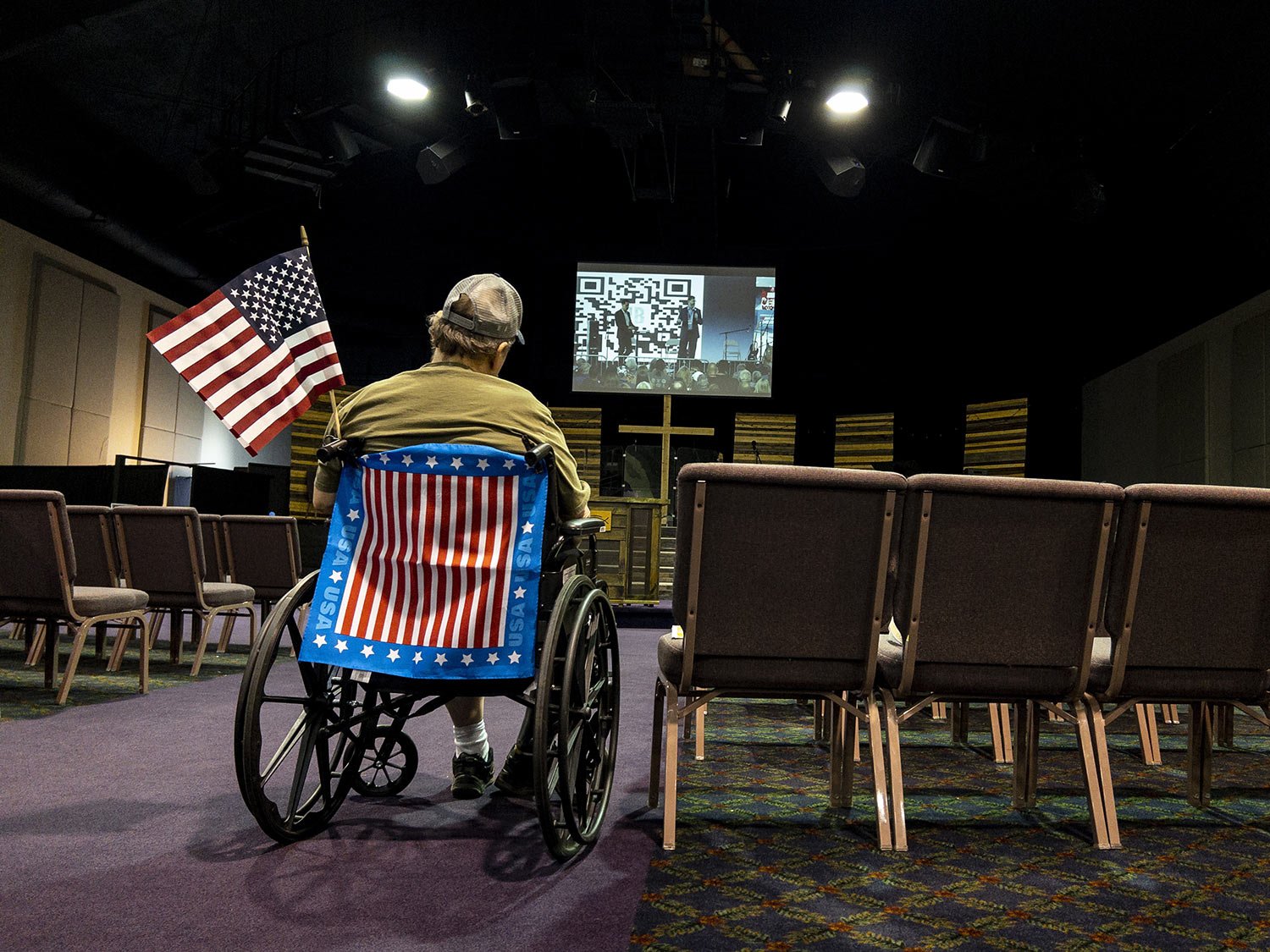  A man watches a live video feed during the ReAwaken America Tour from inside the Cornerstone Church in Batavia, N.Y., Aug. 12, 2022. (AP Photo/Carolyn Kaster) 