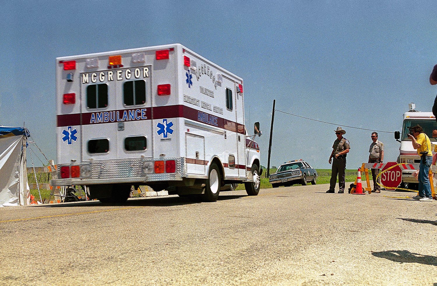  An ambulance passes a Texas Department of Public Safety checkpoint heading towards the Branch Davidian compound in Waco, Texas on Monday, April 19, 1993 as fire engulfed the structure. (AP Photo/Susan Weems) 