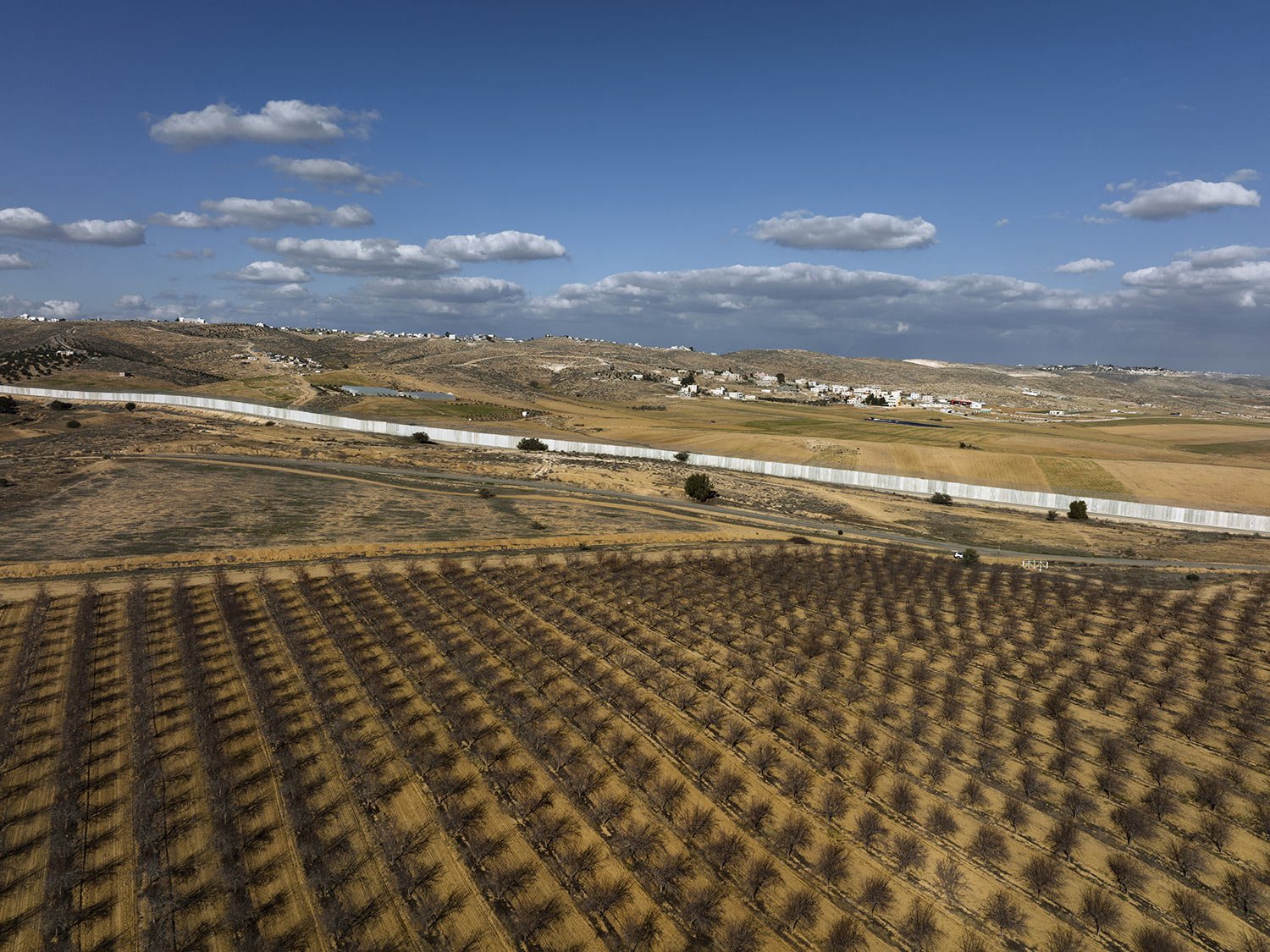  A section of Israel's separation barrier cuts between Israel kibbutz Kramim and the southern West Bank village of Arab al Fureijat, Feb. 1, 2022. (AP Photo/Oded Balilty) 