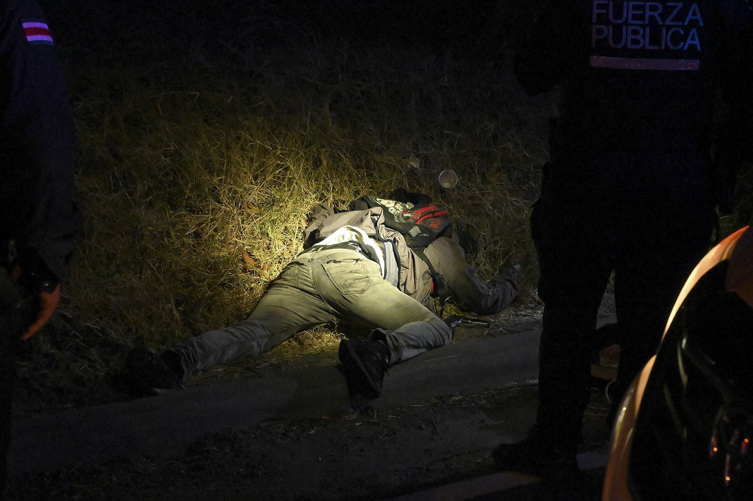  A man’s body is illuminated by police flashlights as investigators work the scene where an alleged thief and a female passenger died in a shootout during a robbery on a bus in San Jose, Costa Rica, Monday, Feb. 6, 2023. According to authorities, Cos