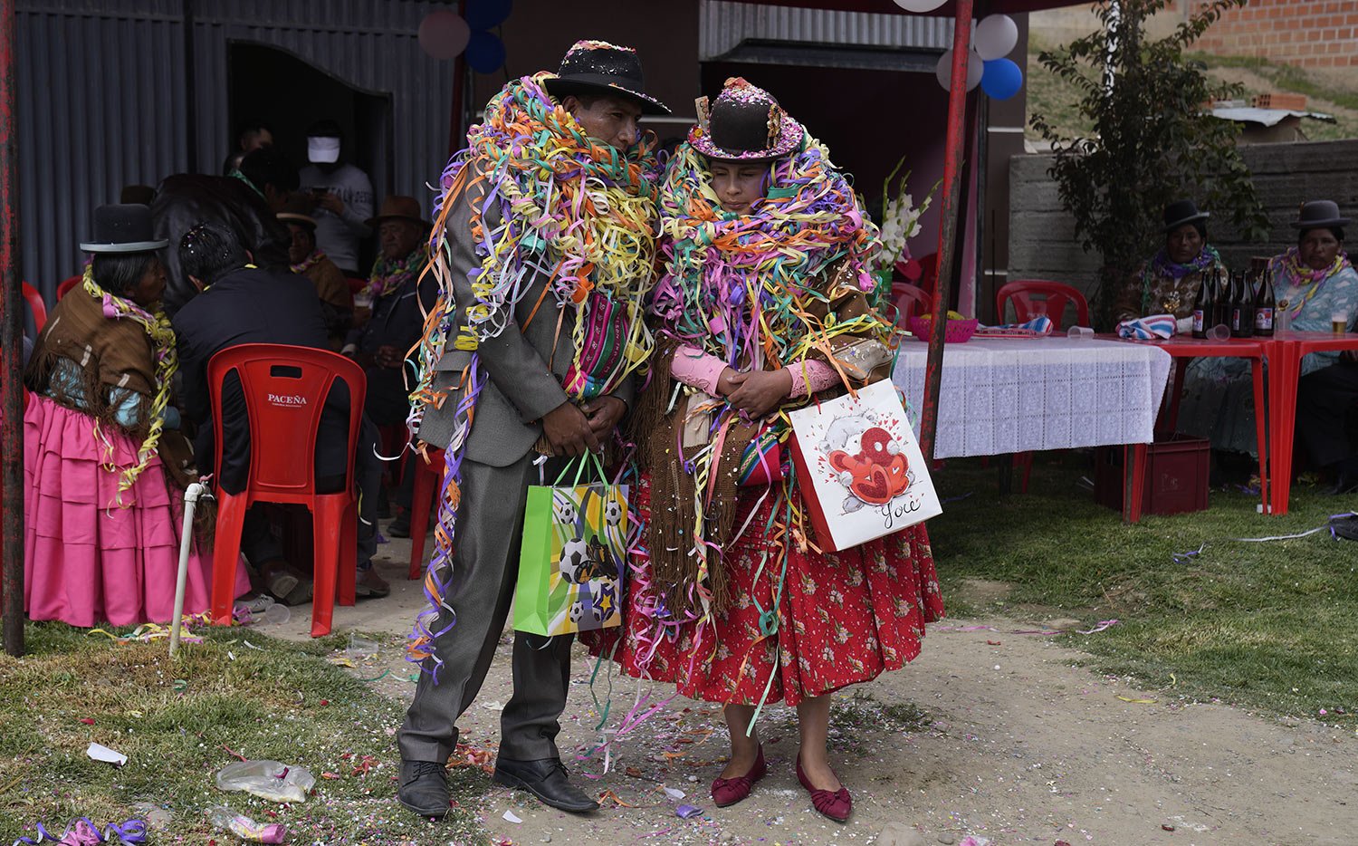  Carnival party hosts, Nelson Chavez and wife Laura Vargas are adorned with party streamers as they await their guests during Challa Tuesday celebrations, in which devotees bury food, toss candies into the air and burn incense, all in a show of grati