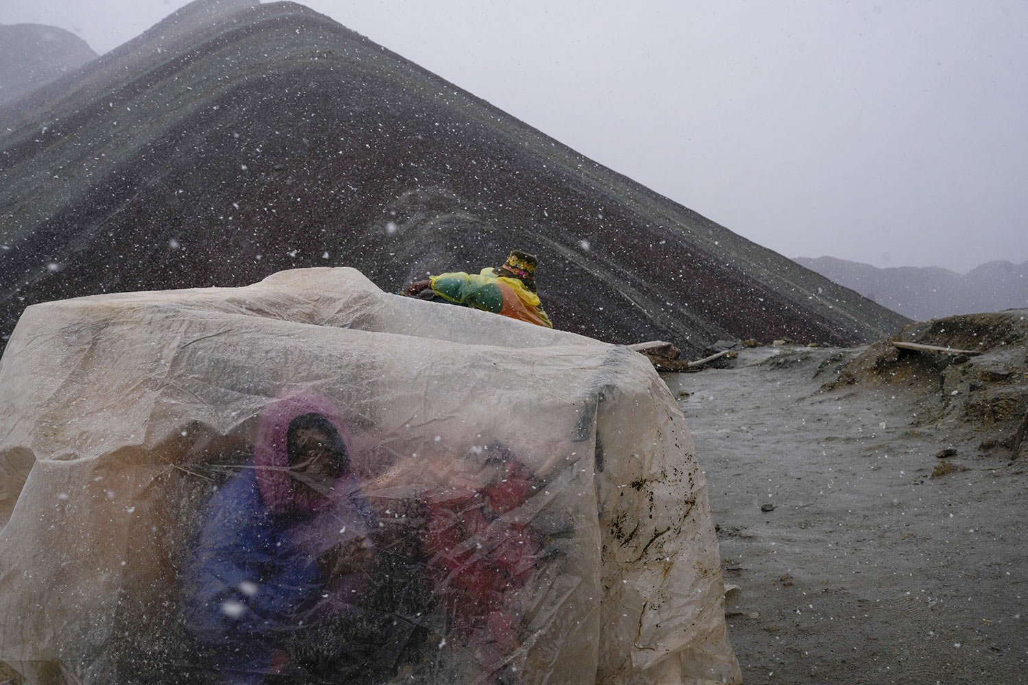  Residents who offer services to tourists visiting the Rainbow Mountain take cover from the weather in Cusipata, Peru, Sunday, Feb. 5, 2023. The mountain is a bustling destination for international tourists but the number of visitors has fallen due t