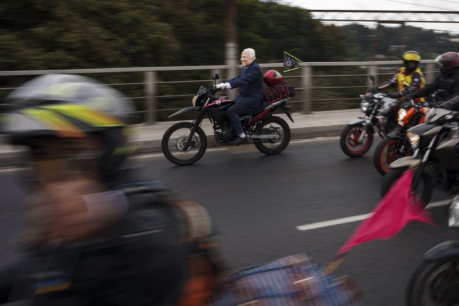 A biker wearing a mask depicting U.S. President Joe Biden rides in the annual motorcycle pilgrimage to the church of the Black Christ of Esquipulas in Guatemala City, Saturday, Feb. 4, 2023. Pilgrims from across Central America traveled to the town 