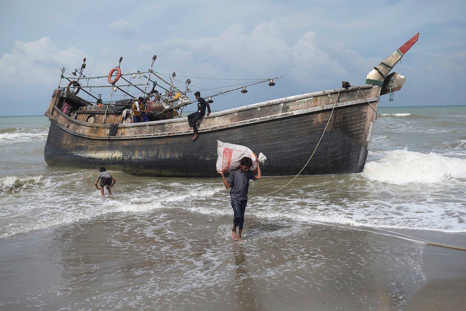  Ethic Rohingya people collect belongings from their boat after landing on Lampanah Leungah beach in Aceh Besar, Aceh province, Indonesia, Thursday, Feb. 16, 2023. (AP Photo/Riska Munawarah) 