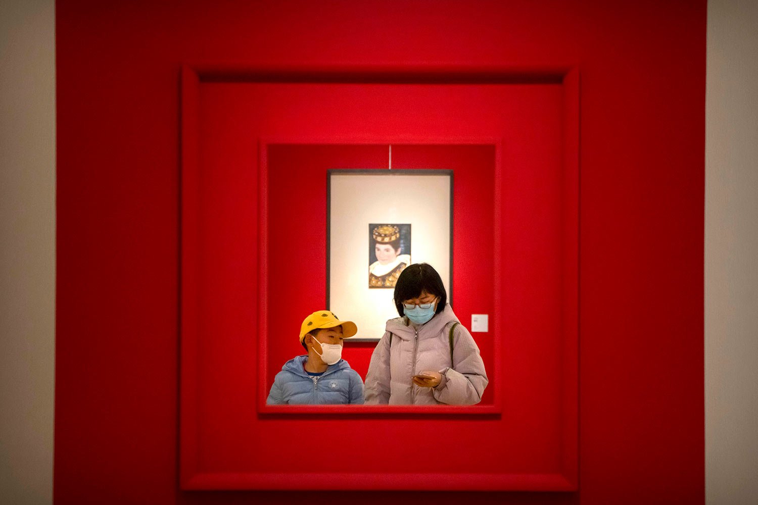  A woman and child wearing face masks walk through a gallery at the National Art Museum of China in Beijing, Wednesday, Feb. 1, 2023. (AP Photo/Mark Schiefelbein) 