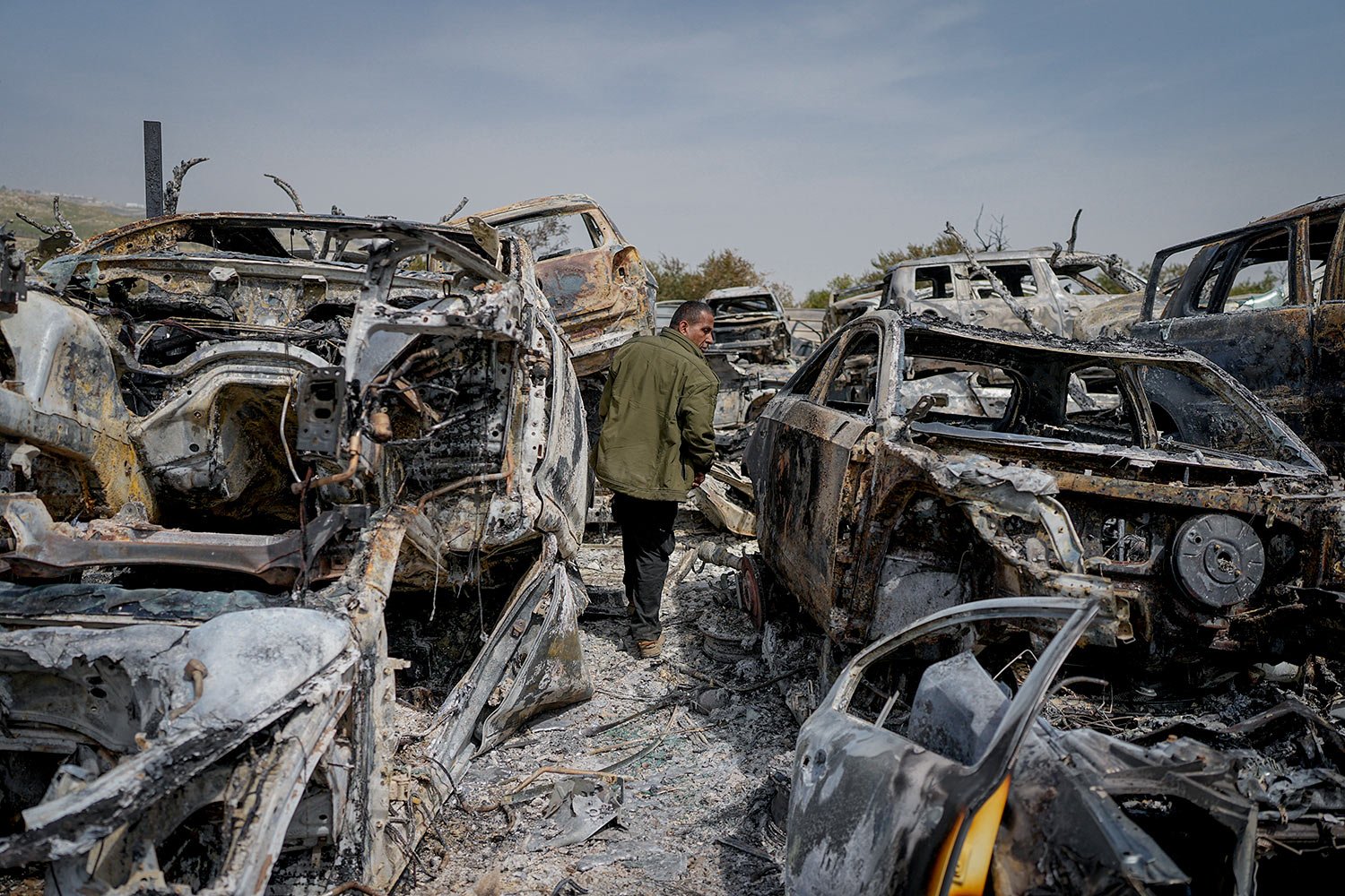  A Palestinian man walks between scorched cars in a scrapyard, in the town of Hawara, near the West Bank city of Nablus, Monday, Feb. 27, 2023.  (AP Photo/Ohad Zwigenberg) 