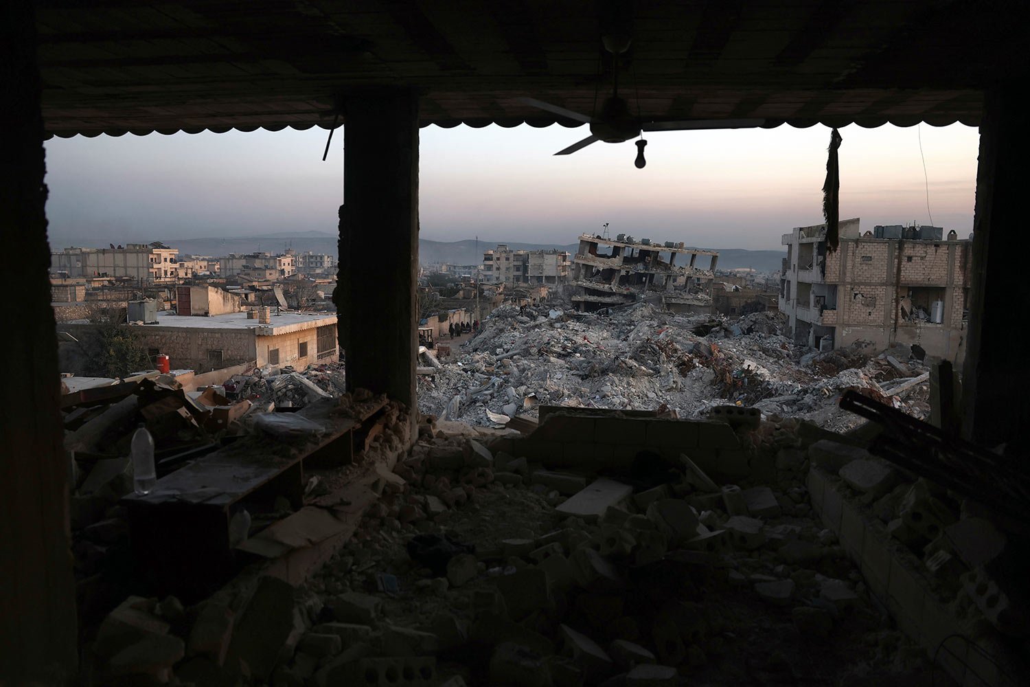  Collapsed buildings are seen through the windows of a damaged house following a devastating earthquake in the town of Jinderis, Aleppo province, Syria, Thursday, Feb. 9, 2023.  (AP Photo/Ghaith Alsayed) 