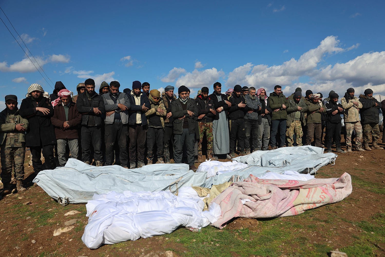  Mourners pray over coffins of family members who died in a devastating earthquake that rocked Syria and Turkey at a cemetery in the town of Jinderis, Aleppo province, Syria, Tuesday, Feb. 7, 2023. AP Photo/Ghaith Alsayed) 