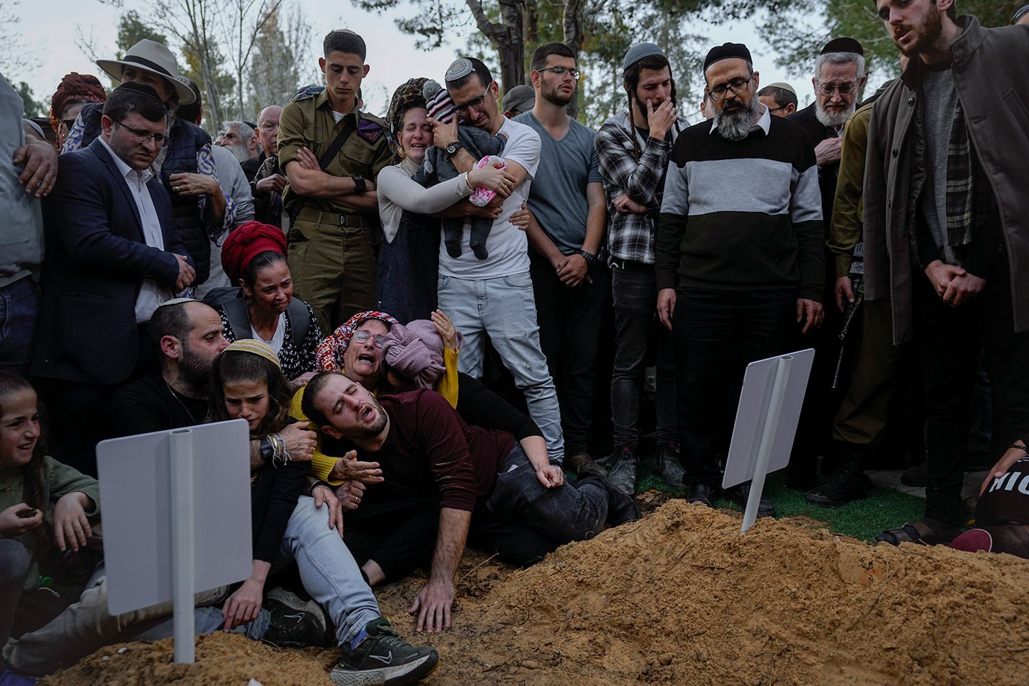  Family members and friends of Hillel Yaniv, 21, and Yagel Yaniv, 19, mourn over their graves during their funeral at Israel's national cemetery in Jerusalem, Monday, Feb. 27, 2023. (AP Photo/Ohad Zwigenberg) 