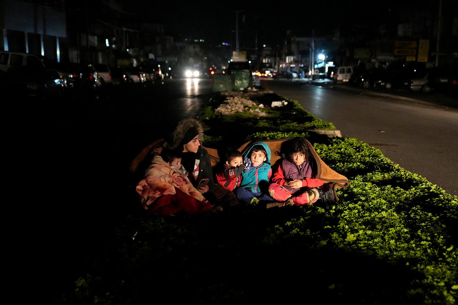  A family, who fled the war in Syria and live in Beirut, sit outside their home following an earthquake that hit neighboring Turkey early Monday, Feb. 6, 2023, in south of Beirut, Lebanon. (AP Photo/Hussein Malla) 