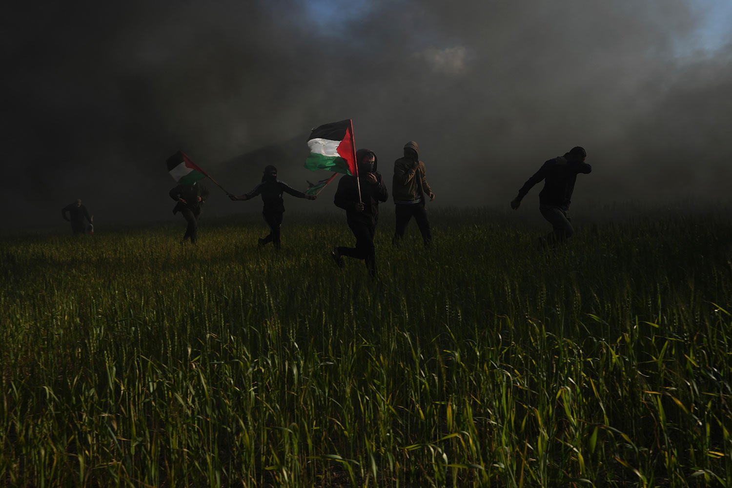  Palestinians carry national flags during a protest against Israeli military raid in the West Bank city of Nablus, along the border fence with Israel, east of Gaza City, Wednesday, Feb. 22, 2023. (AP Photo/Adel Hana) 