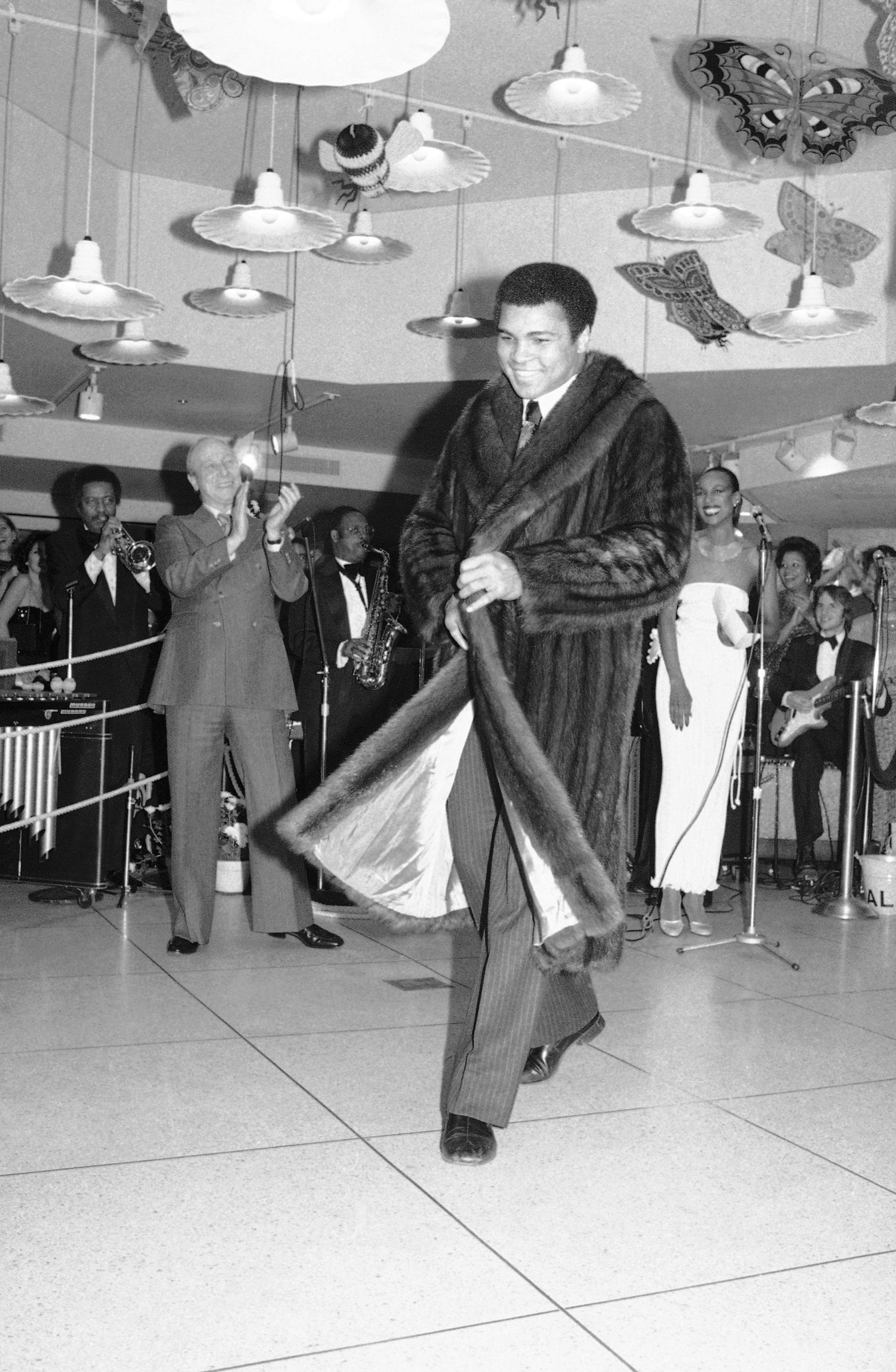  Heavyweight champ Muhammad Ali is a smiling study in sable fur, as he models full length coat during fashion show on Thursday, Dec. 8, 1977 at World Trade Center in New York. He was among the sports greats who modeled during the northside center for