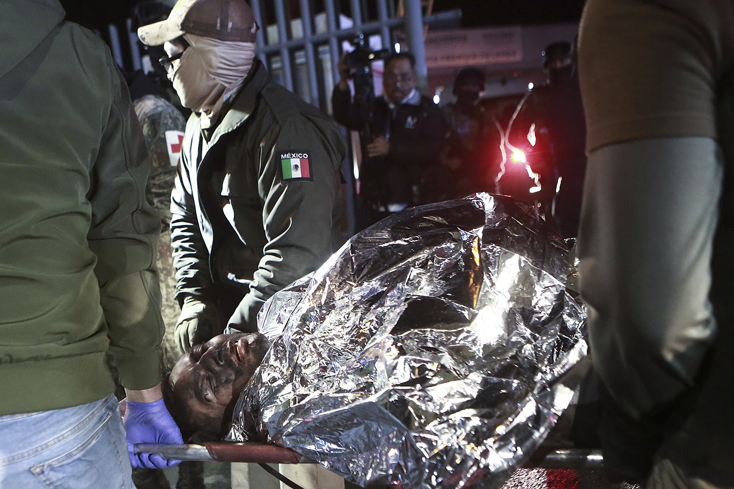  Paramedics carry a migrant who was wounded in a deadly fire at an immigration detention center in Ciudad Juarez, Mexico, March 28, 2023. (AP Photo/Christian Chavez) 