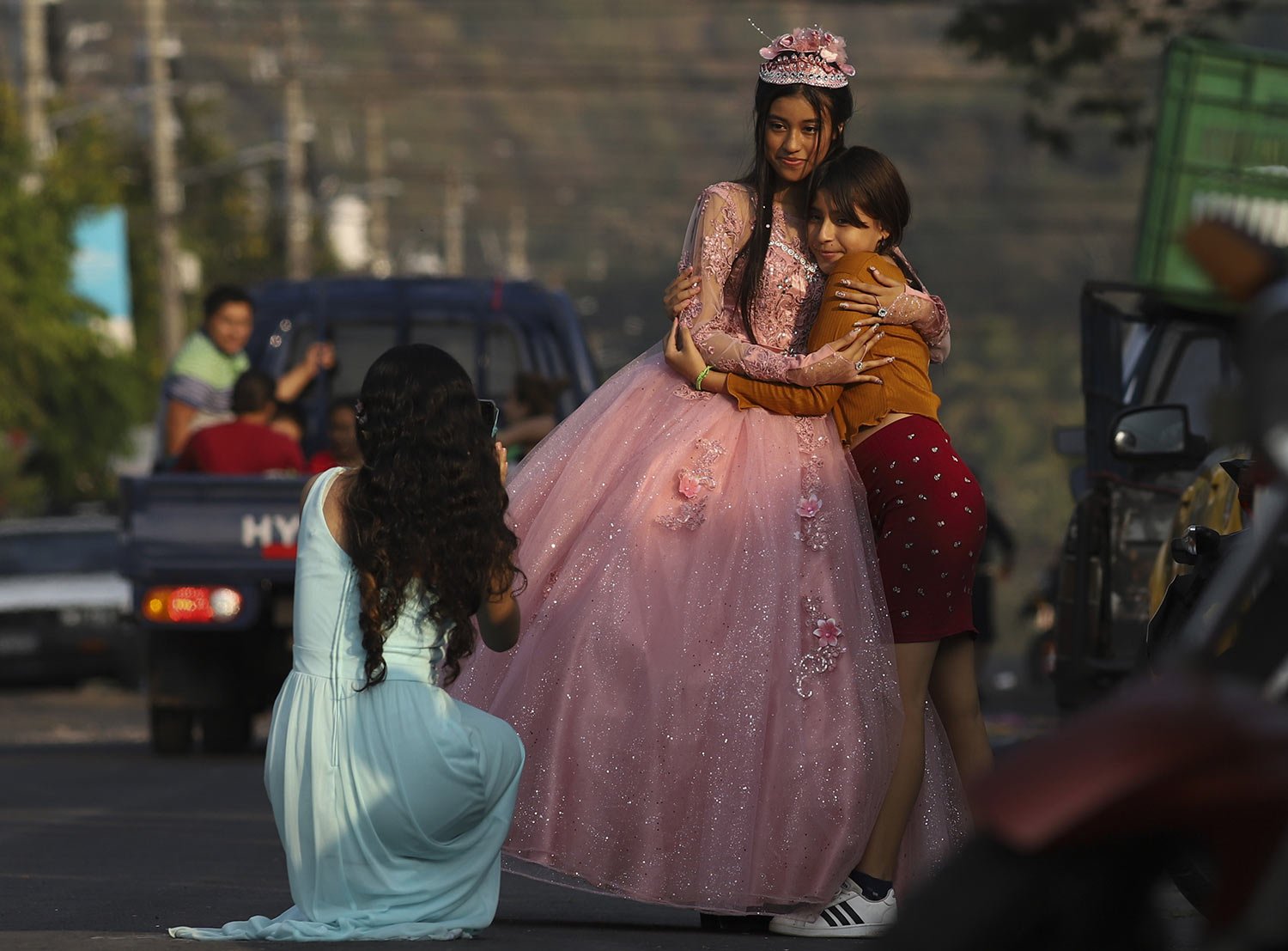  A youth celebrating her 15th birthday, or quinceañera, poses for photos on the main street of La Campanera, during the celebration in an evangelical church in Soyapango, El Salvador, March 5, 2023. Even stepping foot on this street would have been u