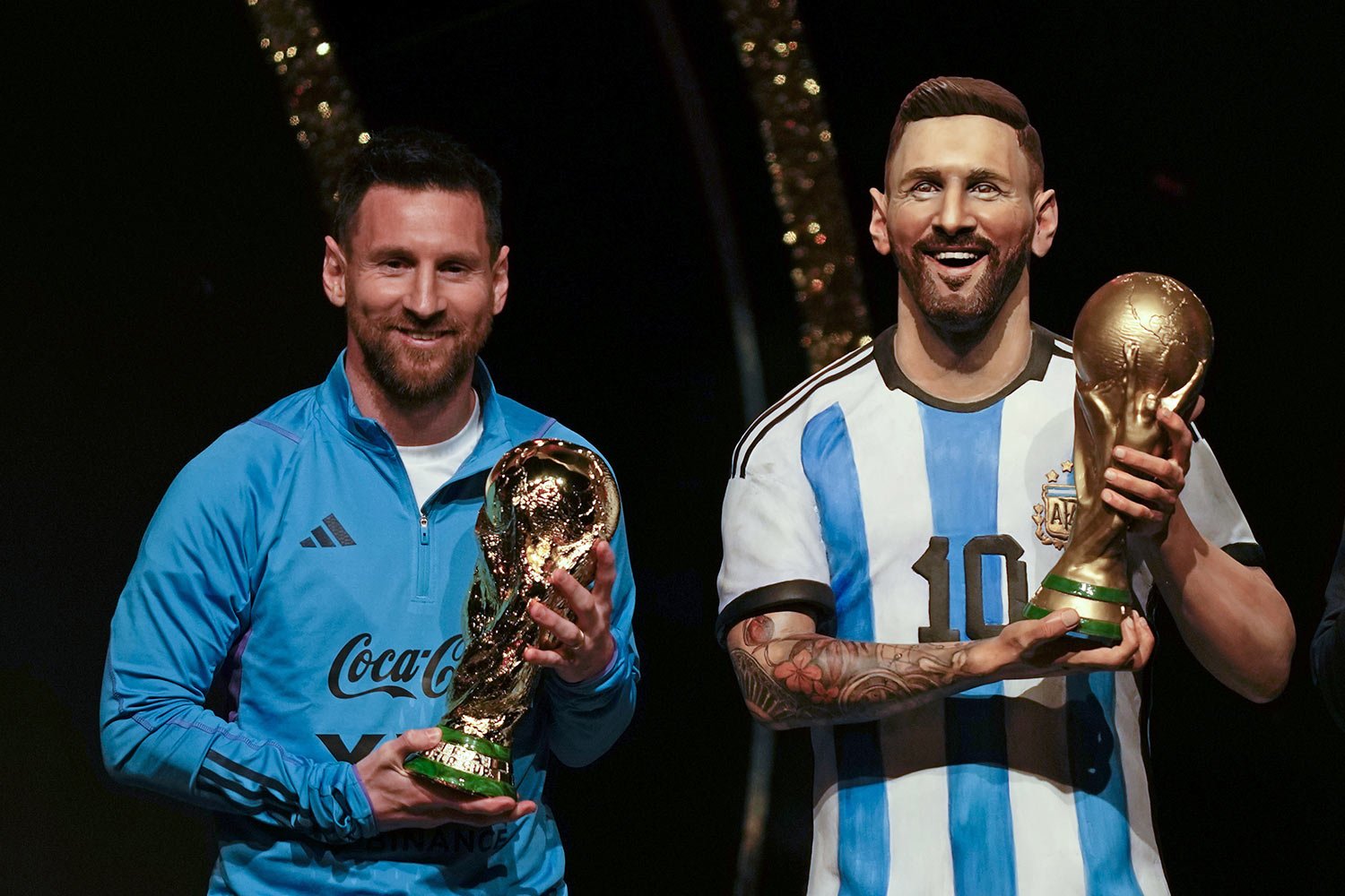  Argentine soccer star Lionel Messi holds a replica of the FIFA World Cup trophy next to a statue of himself during a ceremony at CONMEBOL headquarters in Asuncion, March 27, 2023. CONMEBOL authorities held a ceremony to honor the Argentine squad aft