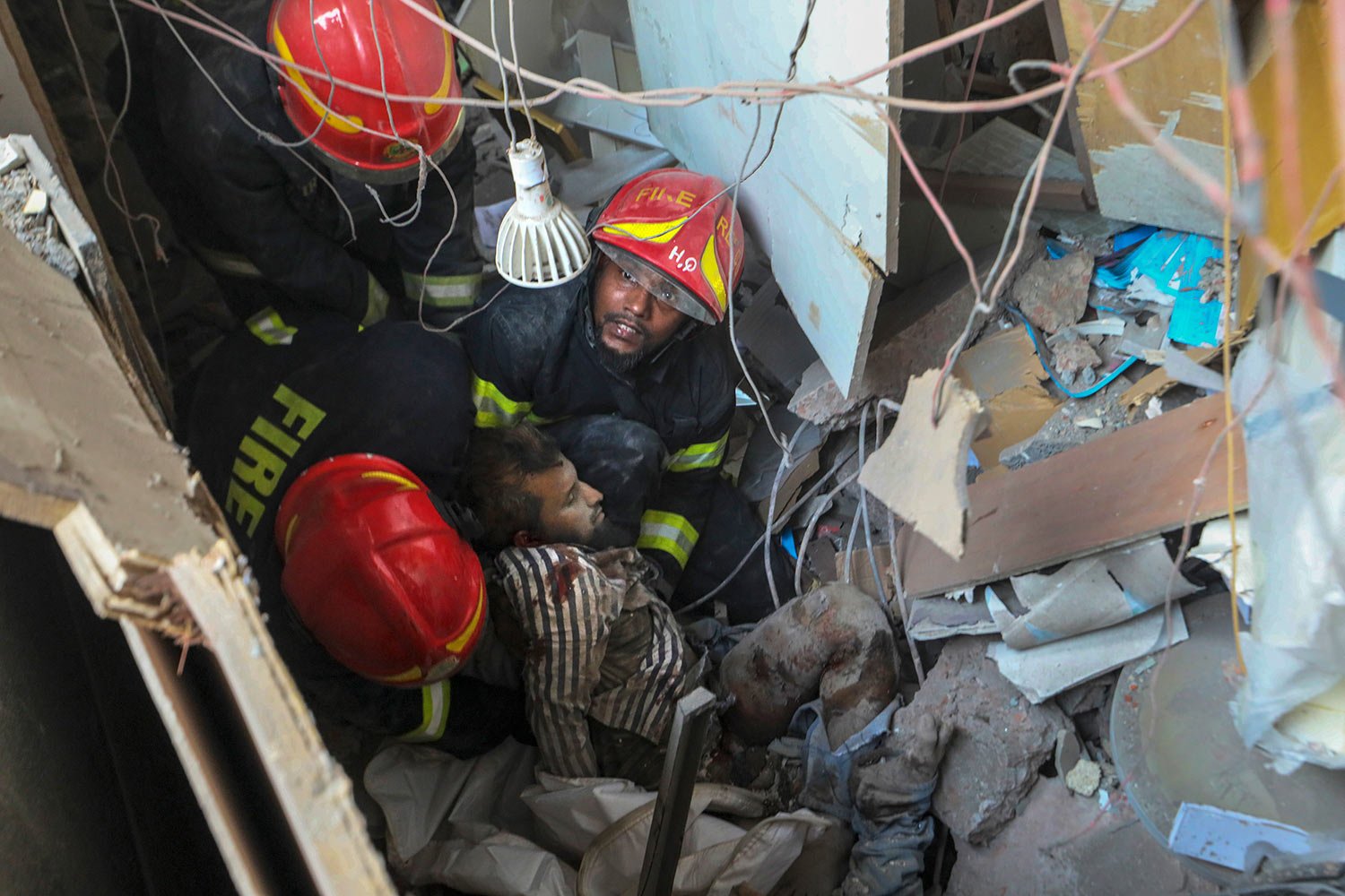  Fire officials rescue an injured person from the debris of a commercial building after an explosion, in Dhaka, Bangladesh, Tuesday, March 7, 2023.  (AP Photo/Abdul Goni) 