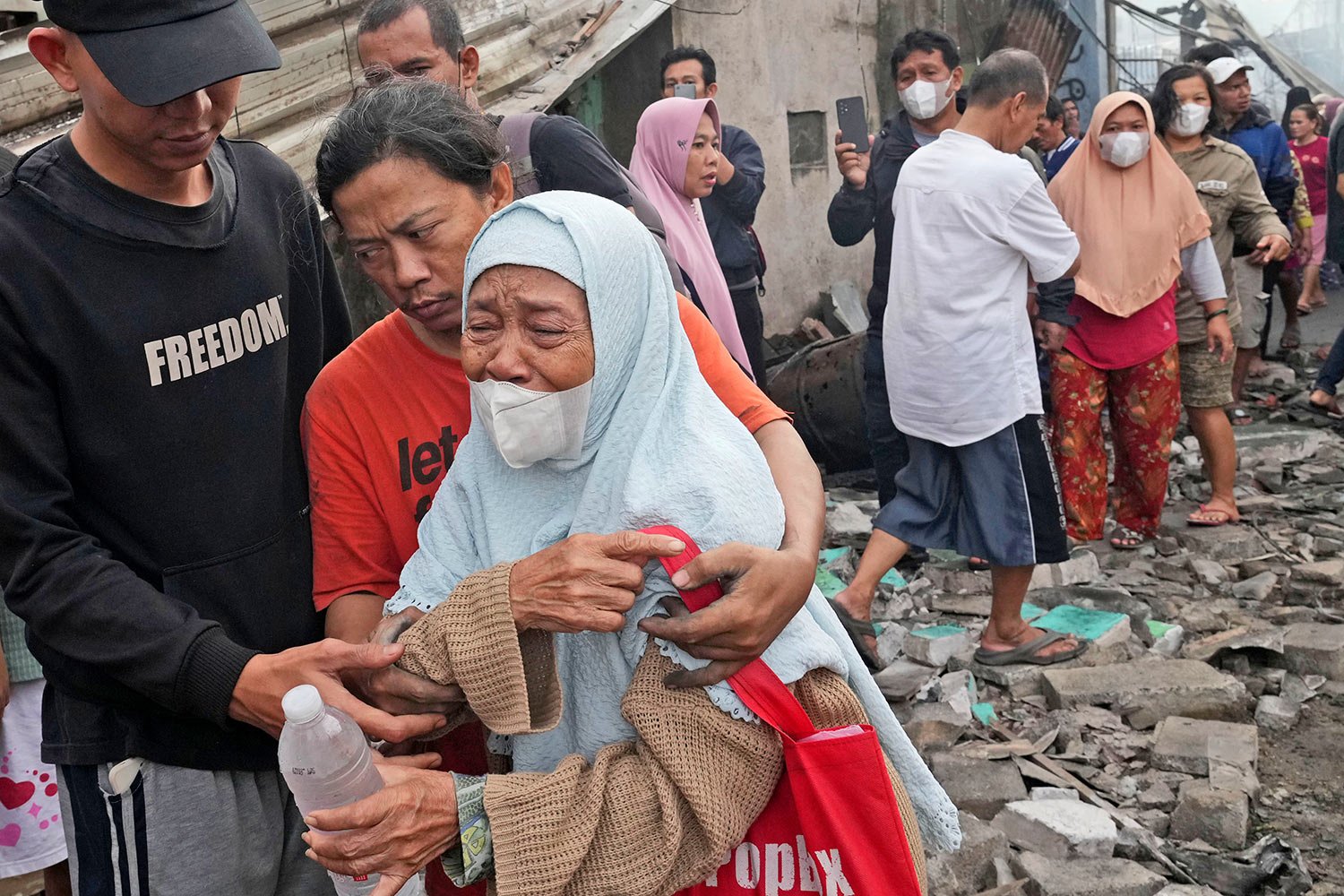  A woman weeps at a neighborhood affected by a fuel depot fire in Jakarta, Indonesia, Saturday, March 4, 2023.  (AP Photo/Tatan Syuflana) 