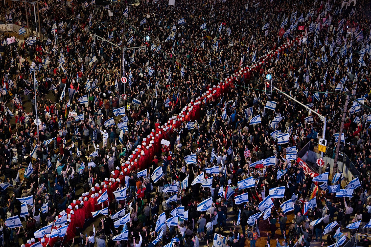  A line of protesters supporting women's rights, dressed as characters from The Handmaid's Tale television series, and other Israelis protest against plans by Prime Minister Benjamin Netanyahu's government to overhaul the judicial system in Tel Aviv,