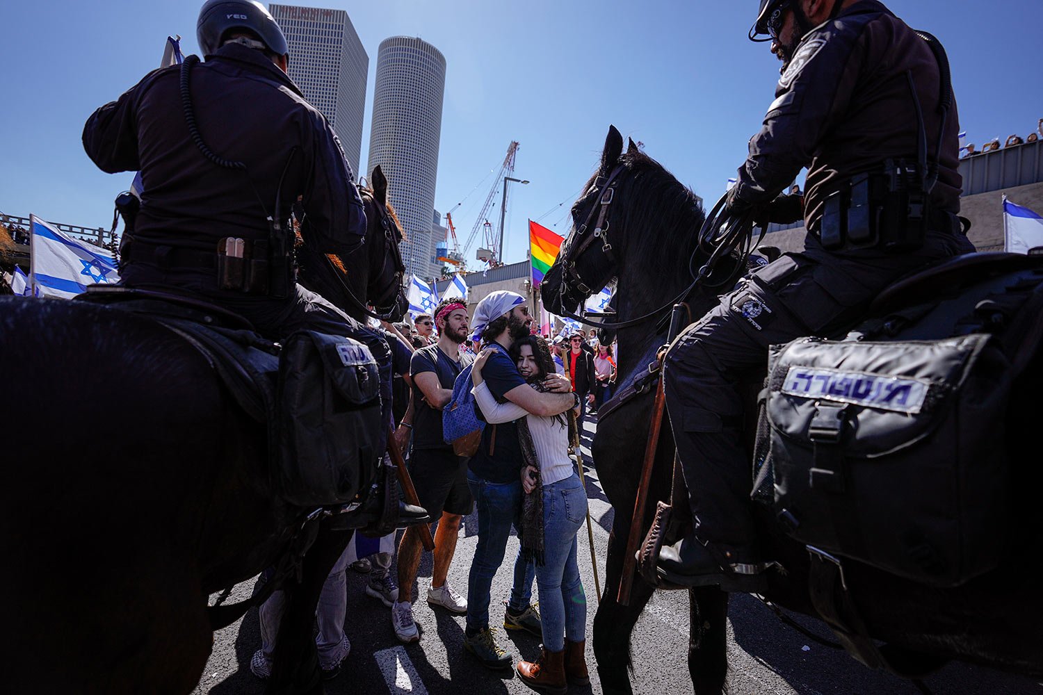  Two demonstrators hug as mounted police officers disperse people blocking a highway during a protest against plans by Prime Minister Benjamin Netanyahu's government to overhaul the Israel's judicial system in Tel Aviv, Israel, Thursday, March 16, 20