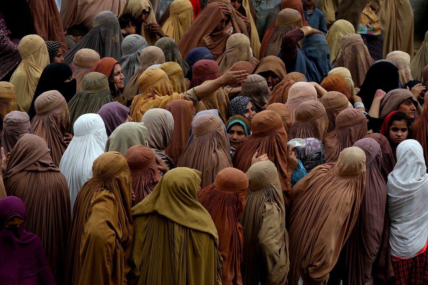 Women gather and wait their turn to get a free sack of wheat flour at a distribution point, in Peshawar, Pakistan, Wednesday, March 29, 2023. (AP Photo/Muhammad Sajjad) 