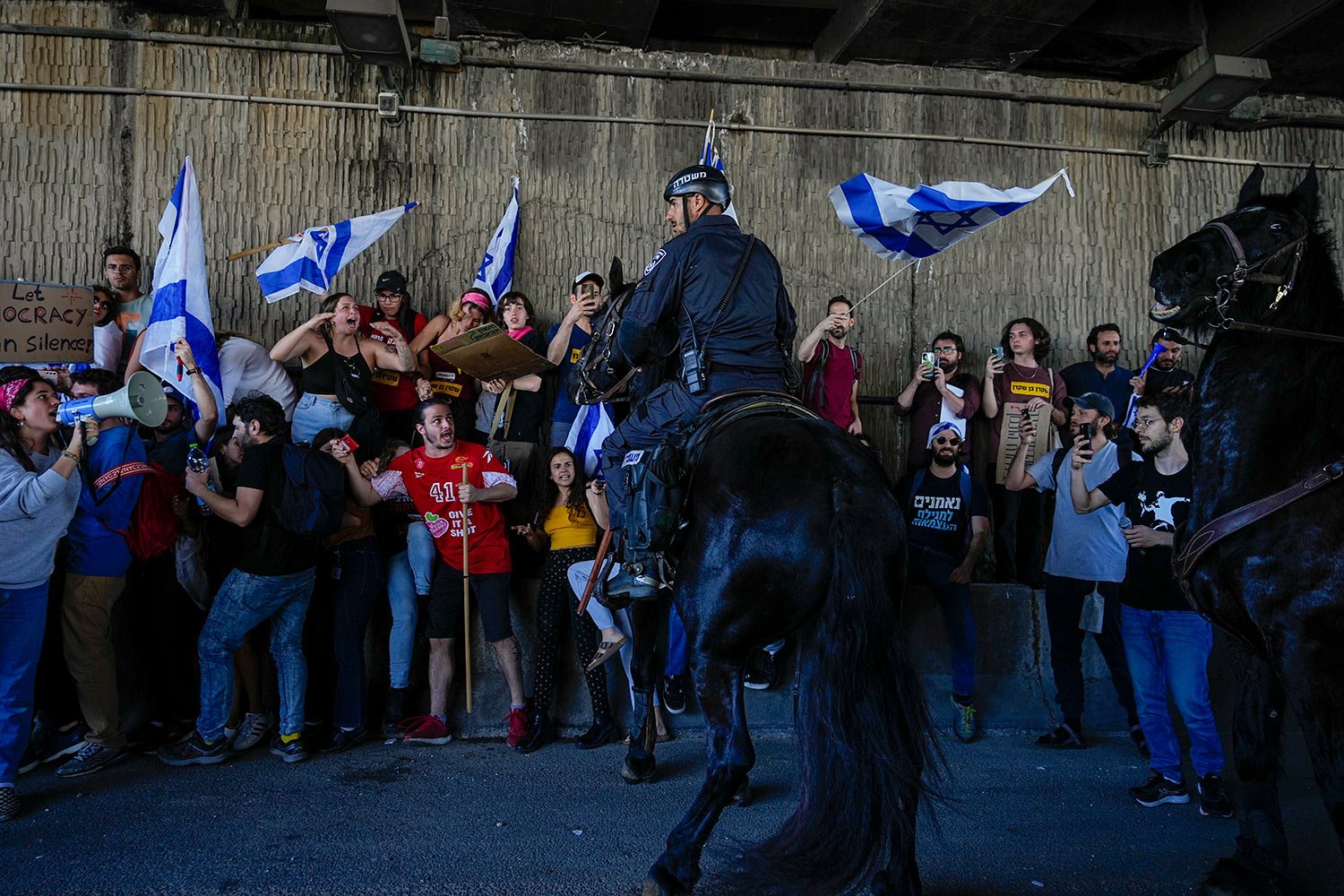  Israeli mounted police officers disperse demonstrators blocking a highway during a protest against plans by Prime Minister Benjamin Netanyahu's government to overhaul the judicial system in Tel Aviv, Israel, Thursday, March 16, 2023. (AP Photo/Ohad 