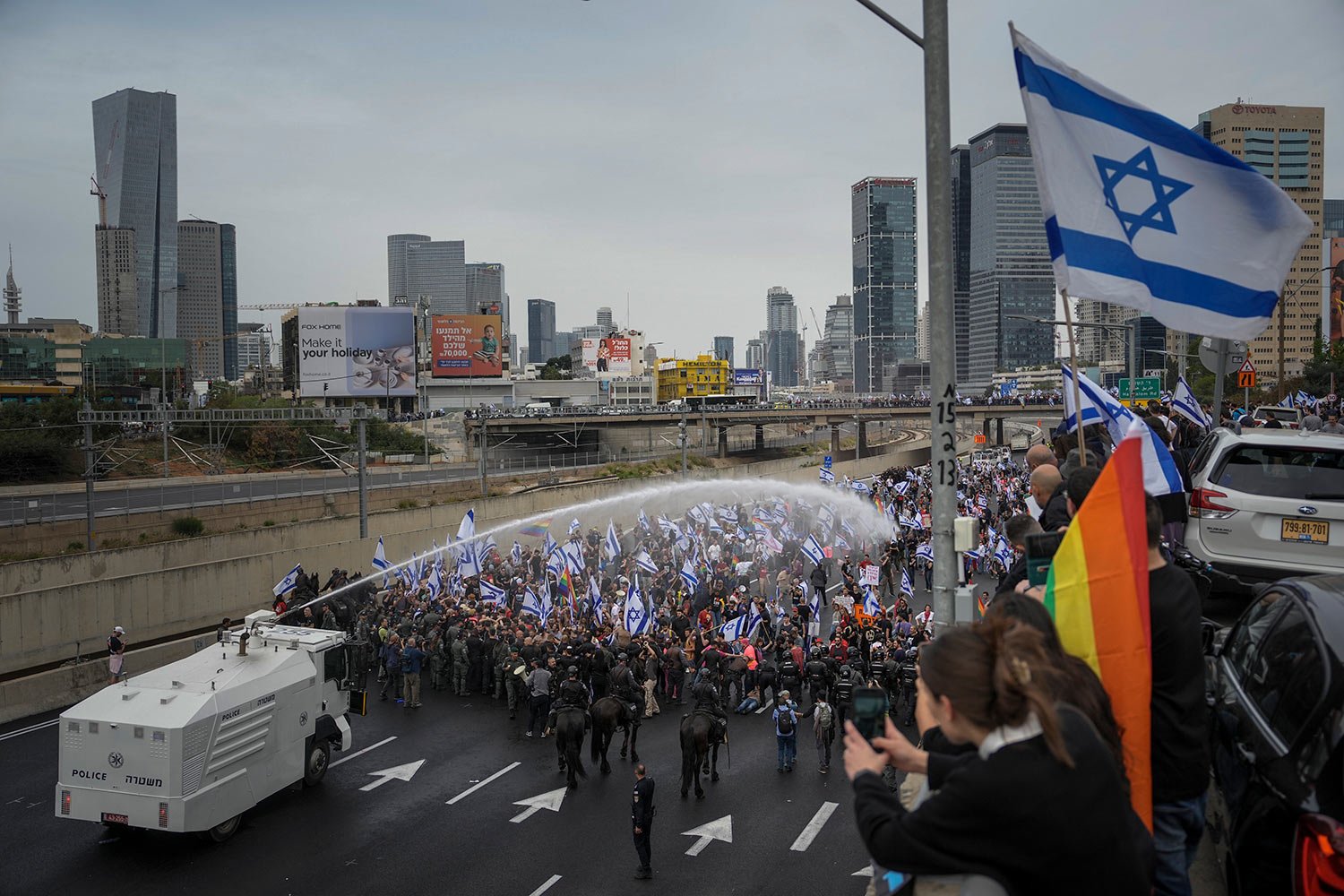  Israeli police use a water cannon to disperse Israelis blocking the freeway during a protest against plans by Prime Minister Benjamin Netanyahu's government to overhaul the judicial system in Tel Aviv, Israel, Thursday, March 23, 2023. (AP Photo/Ode