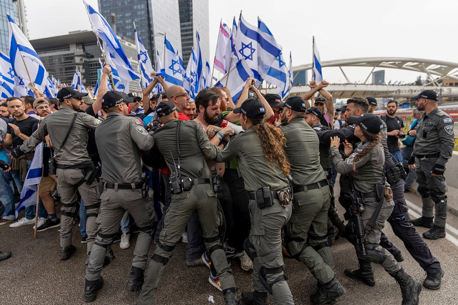  Israeli police scuffle with demonstrators blocking a road during a protest against plans by Prime Minister Benjamin Netanyahu's government to overhaul the judicial system in Tel Aviv, Israel, Thursday, March 23, 2023. (AP Photo/Ohad Zwigenberg) 