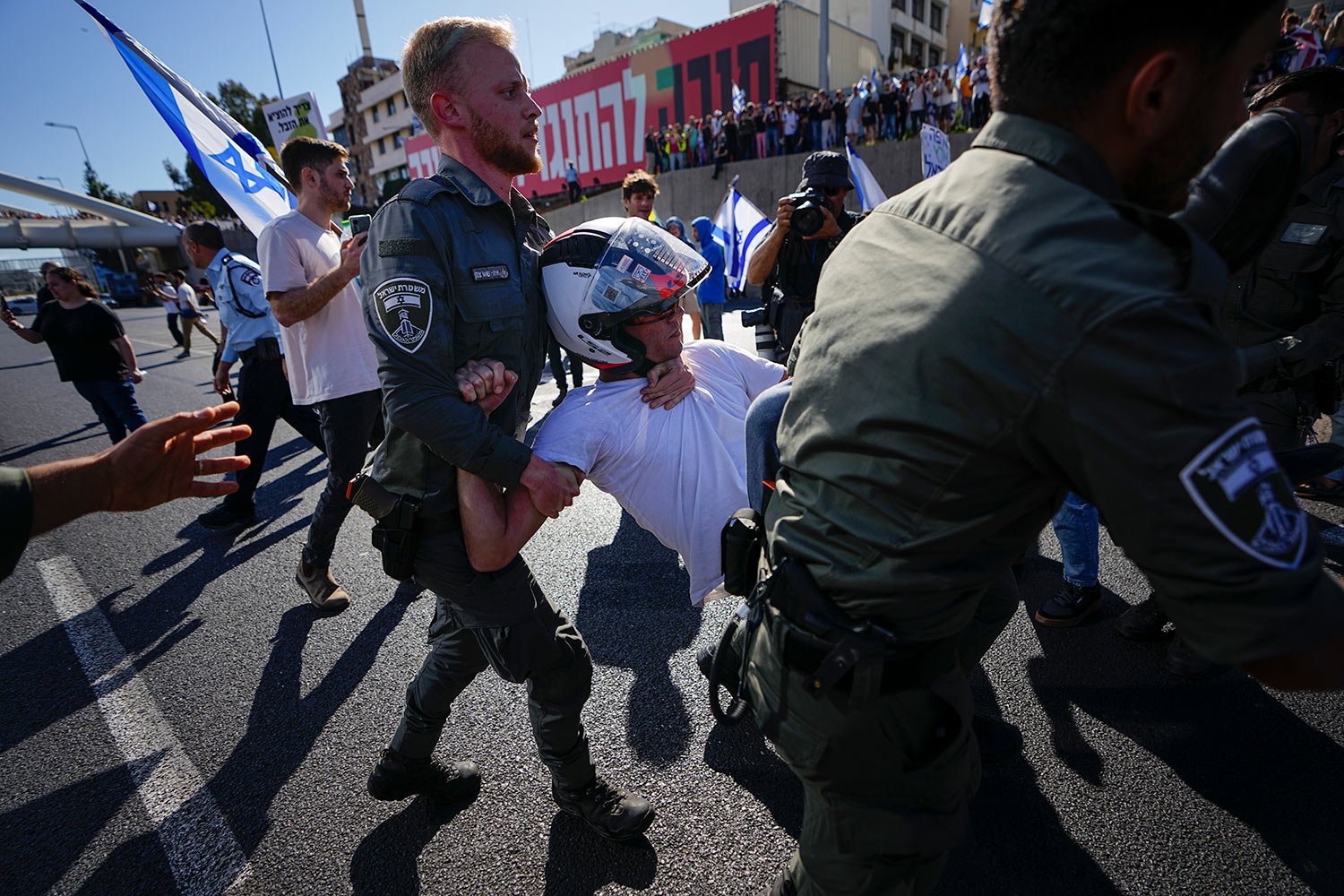  Israeli border police officers disperse demonstrators blocking a highway during a protest against plans by Prime Minister Benjamin Netanyahu's government to overhaul the judicial system, in Tel Aviv, Israel, Thursday, March 9, 2023. (AP Photo/Ariel 