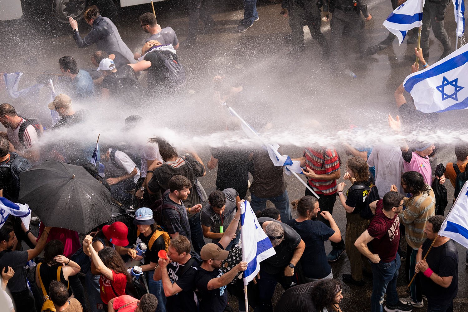  Israeli police use a water cannon to disperse Israelis blocking the freeway during a protest against plans by Prime Minister Benjamin Netanyahu's government to overhaul the judicial system in Tel Aviv, Israel, Thursday, March 23, 2023. (AP Photo/Ode