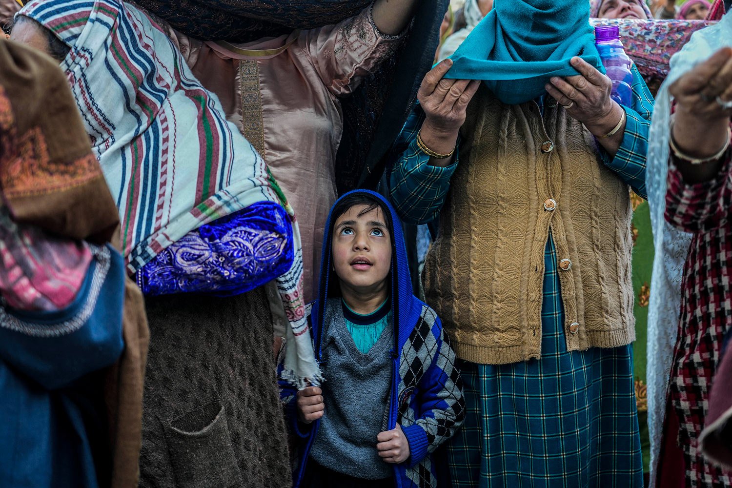  A Kashmiri Muslim boy stands with elders as the head priest displays a holy relic believed to be a hair from the beard of the Prophet Muhammad during special prayers to observe the martyr day of Hazrat Ali, the fourth caliph of Islam, at Hazratbal s