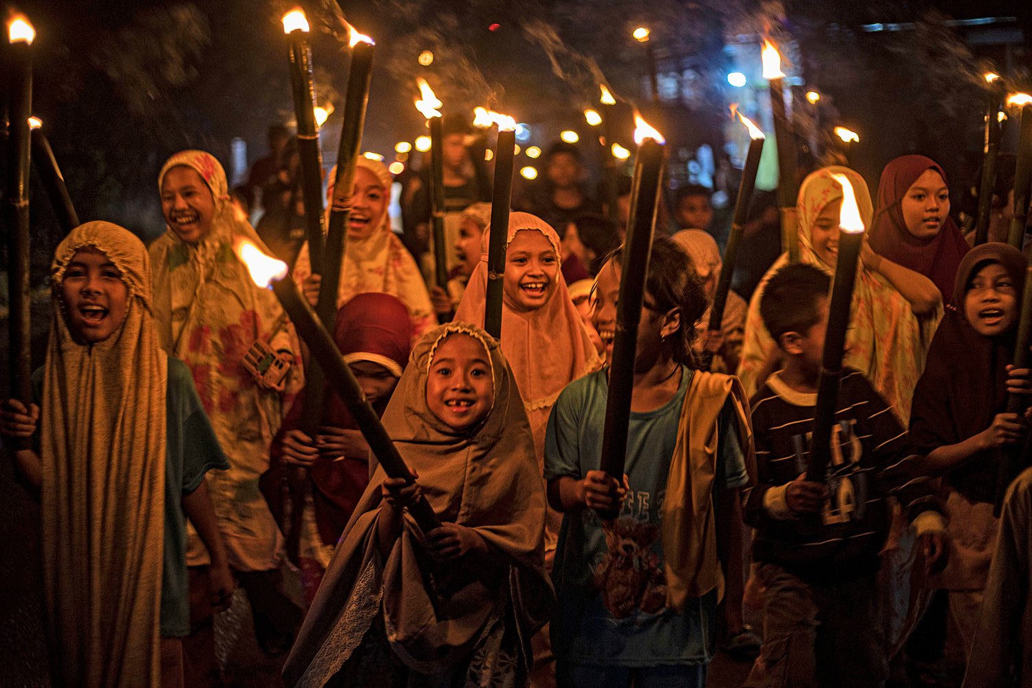  Muslim girls carry torches as they parade to celebrate the eve of Eid al-Fitr, the holiday marking the end of the holy fasting month of Ramadan, in Polewali Mandar, West Sulawesi, Indonesia, Friday, April 21, 2023. (AP Photo/Yusuf Wahil) 