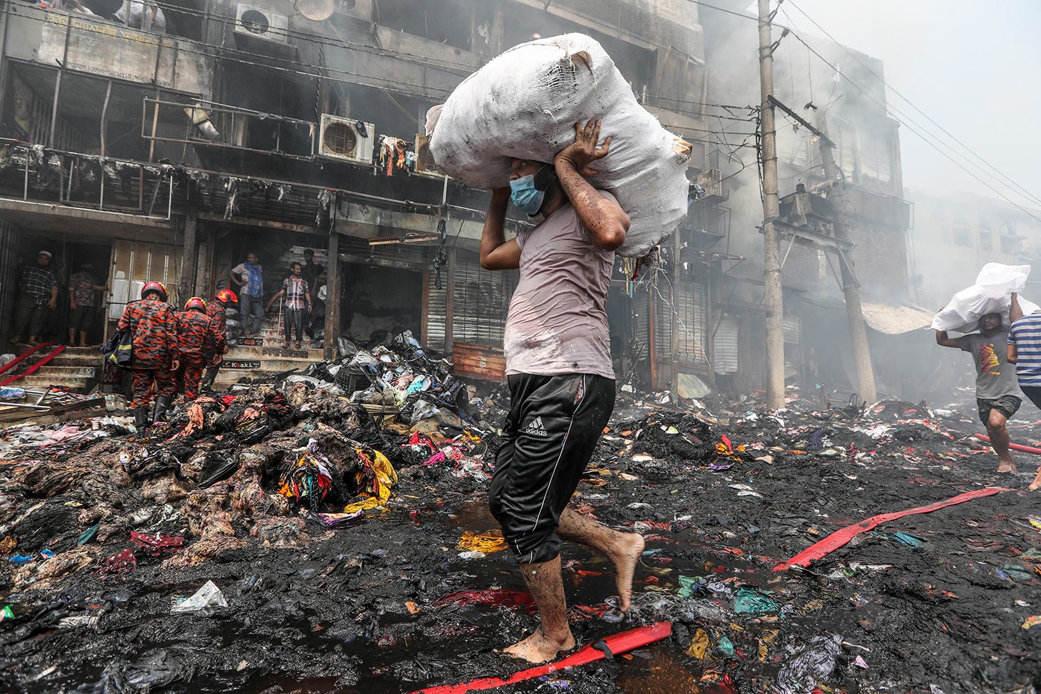  Shopkeepers salvage their goods from nearby shops as a fire rages at a popular market for cheaper clothes in Bangladesh's capital Dhaka, Bangladesh, Tuesday, April 4, 2023. (AP Photo/Mahmud Hossain Opu) 