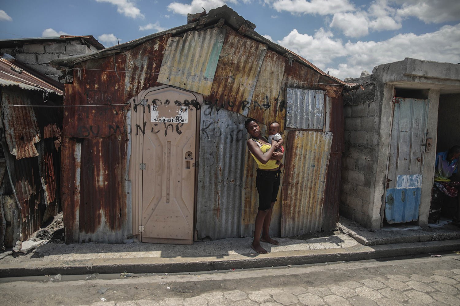  A woman poses for a photo outside the home she built after gangs set her other home on fire in the Cite Soleil slum of Port-au-Prince, Haiti, April 20, 2023. (AP Photo/Odelyn Joseph) 