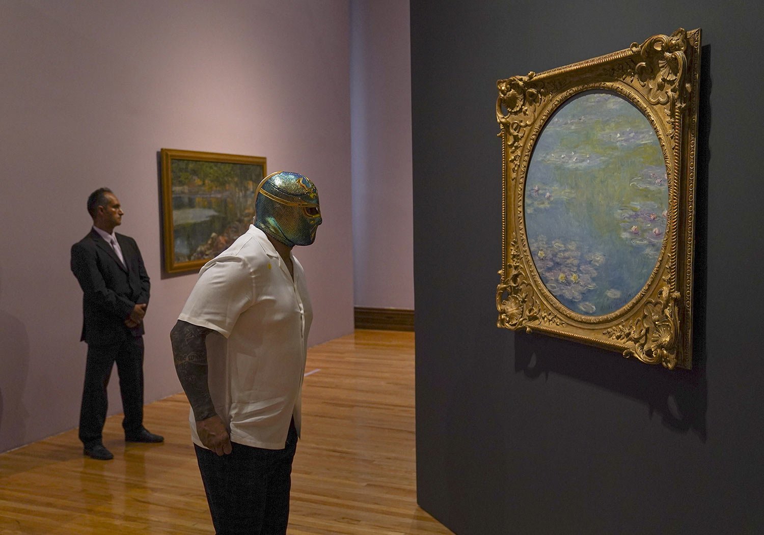  The Mexican Lucha Libre wrestler “CintaDeOro,” or Gold Belt, looks at a painting by Claude Monet during the inauguration of a Monet exhibition at the National Arts Museum in Mexico City, April 26, 2023. (AP Photo/Fernando Llano) 