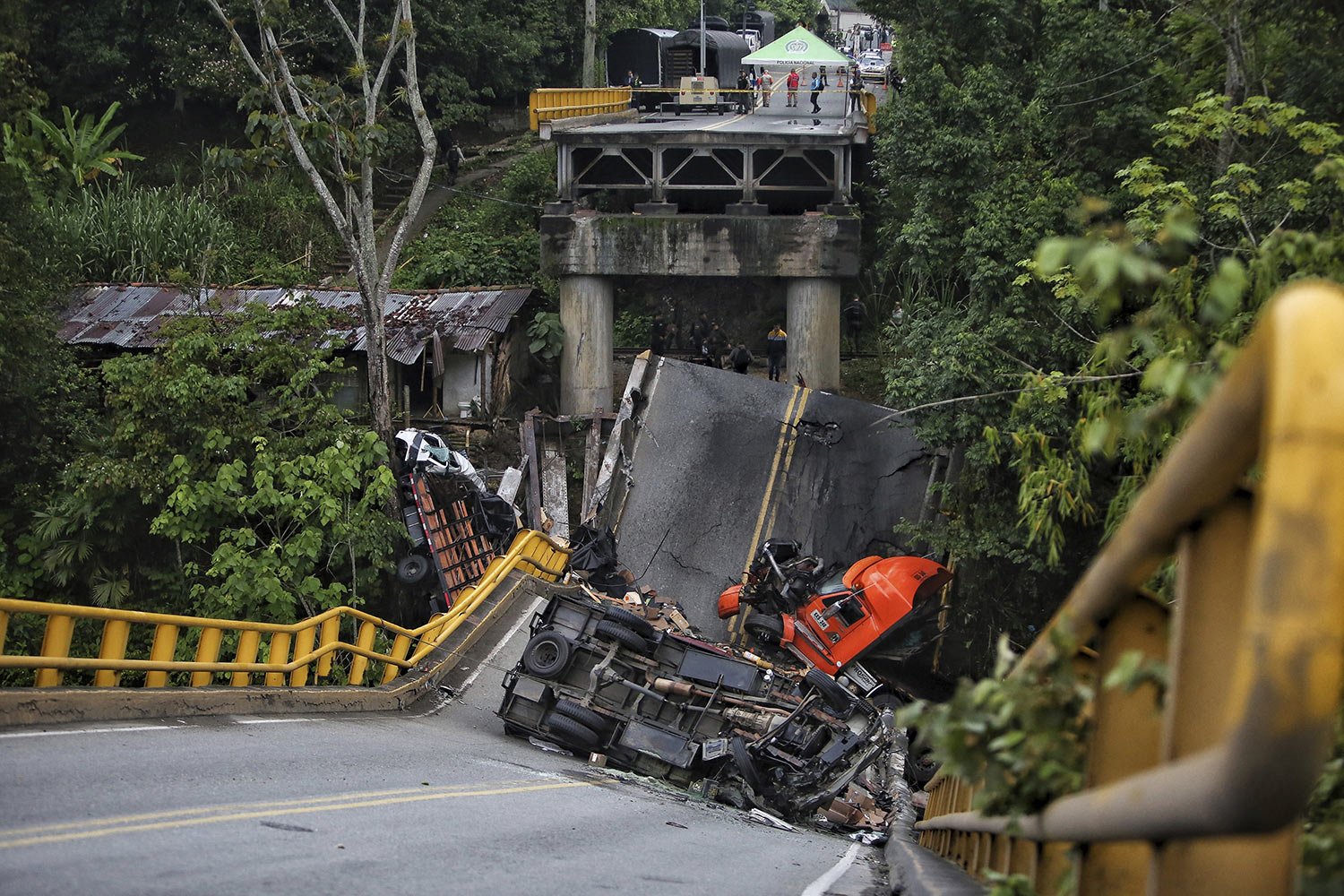  Crashed vehicles lay on and under the El Alambrado bridge after it collapsed the previous day in Caicedonia, Colombia, April 13, 2023. Two people died and over a dozen were injured, according to authorities. (AP Photo/Andres Quintero) 