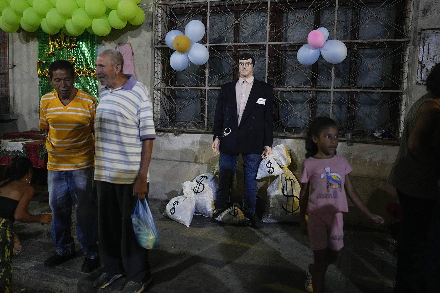  An effigy, labeled "corrupt one,” surrounded with props representing bags of money, is displayed on a sidewalk before it is ignited during the annual Burning of Judas celebrations in Caracas, Venezuela, April 9, 2023. Originally, the burning figures