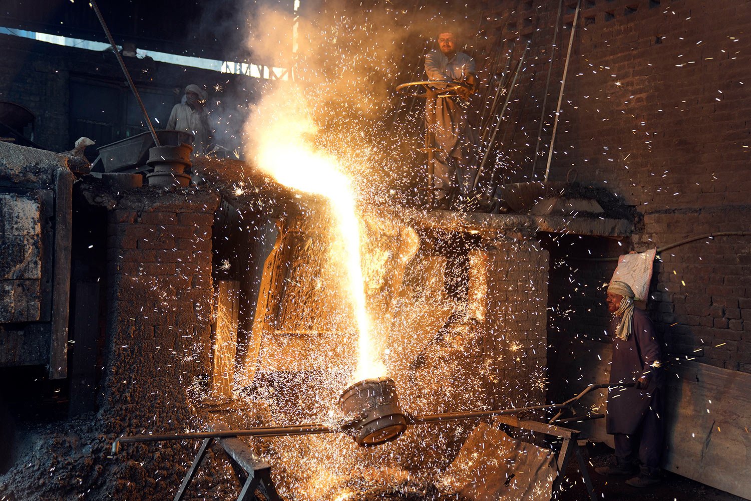  Laborers pour molten metalcin at a steel factory in Lahore, Pakistan, Saturday, April 29, 2023. (AP Photo/K.M. Chaudary) 