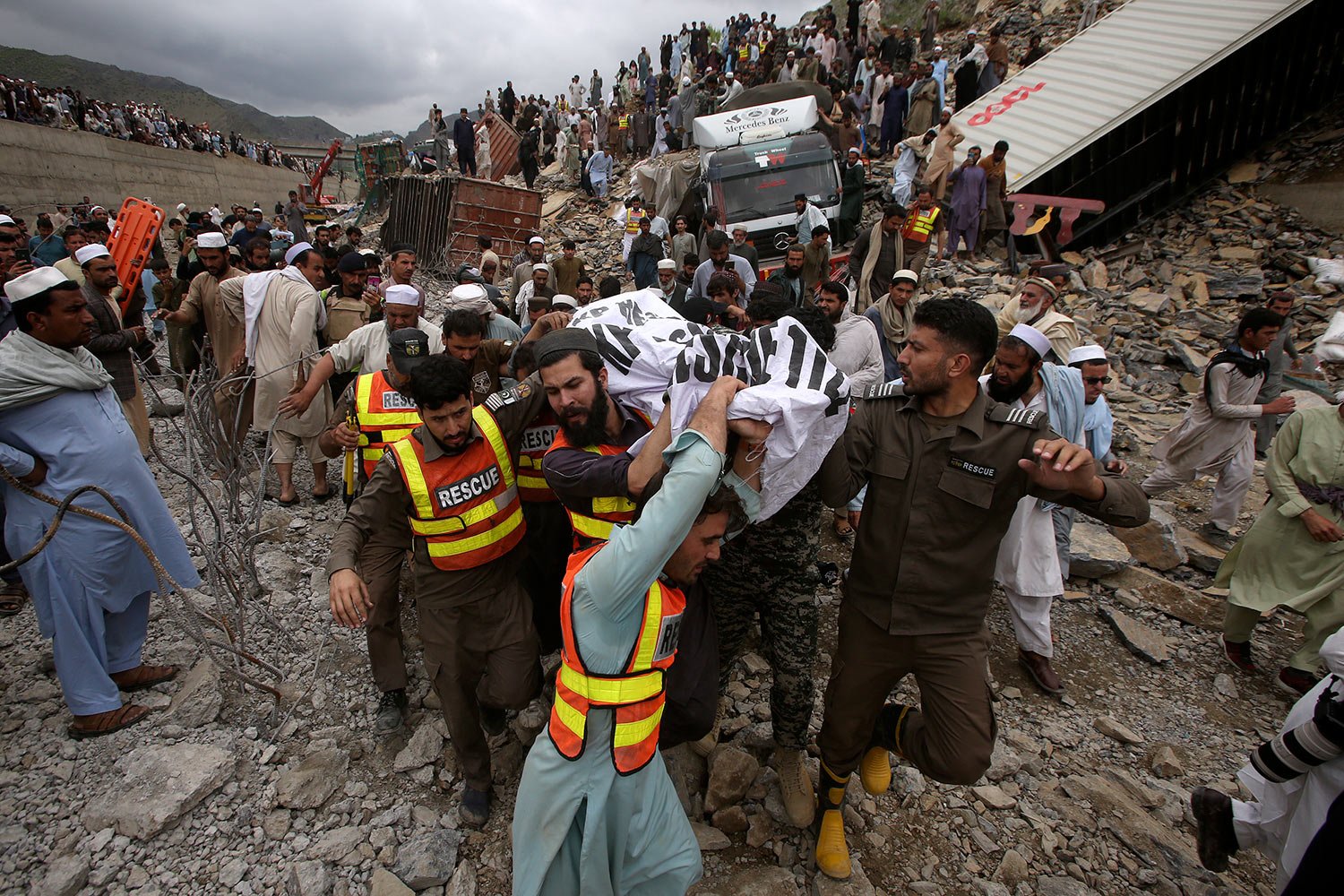  Rescue workers and volunteers carry a body after recovering it from the rubble at the site of landslide near the Torkham border town, Pakistan, Tuesday, April 18, 2023. (AP Photo/Muhammad Sajjad) 