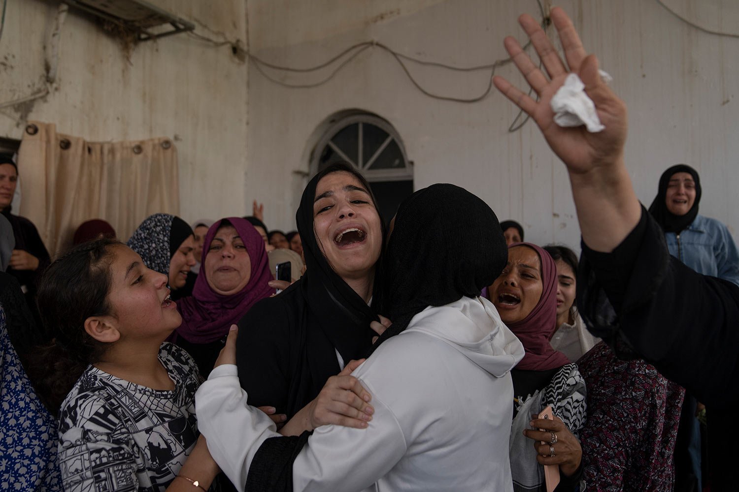  Palestinian mourners cry after taking the last look at the body of Mohammad Balhan, 15, during his funeral in the West Bank refugee camp of Aqabat Jaber, Jericho, Monday, April 10, 2023. (AP Photo/Nasser Nasser) 