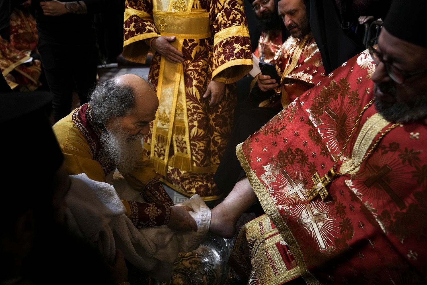  Patriarch Theophilos III, the Greek Orthodox Patriarch of Jerusalem, left, performs the Washing of the Feet ceremony during Holy Week, at the Church of the Holy Sepulcher, where many Christians believe Jesus was crucified, buried and rose from the d