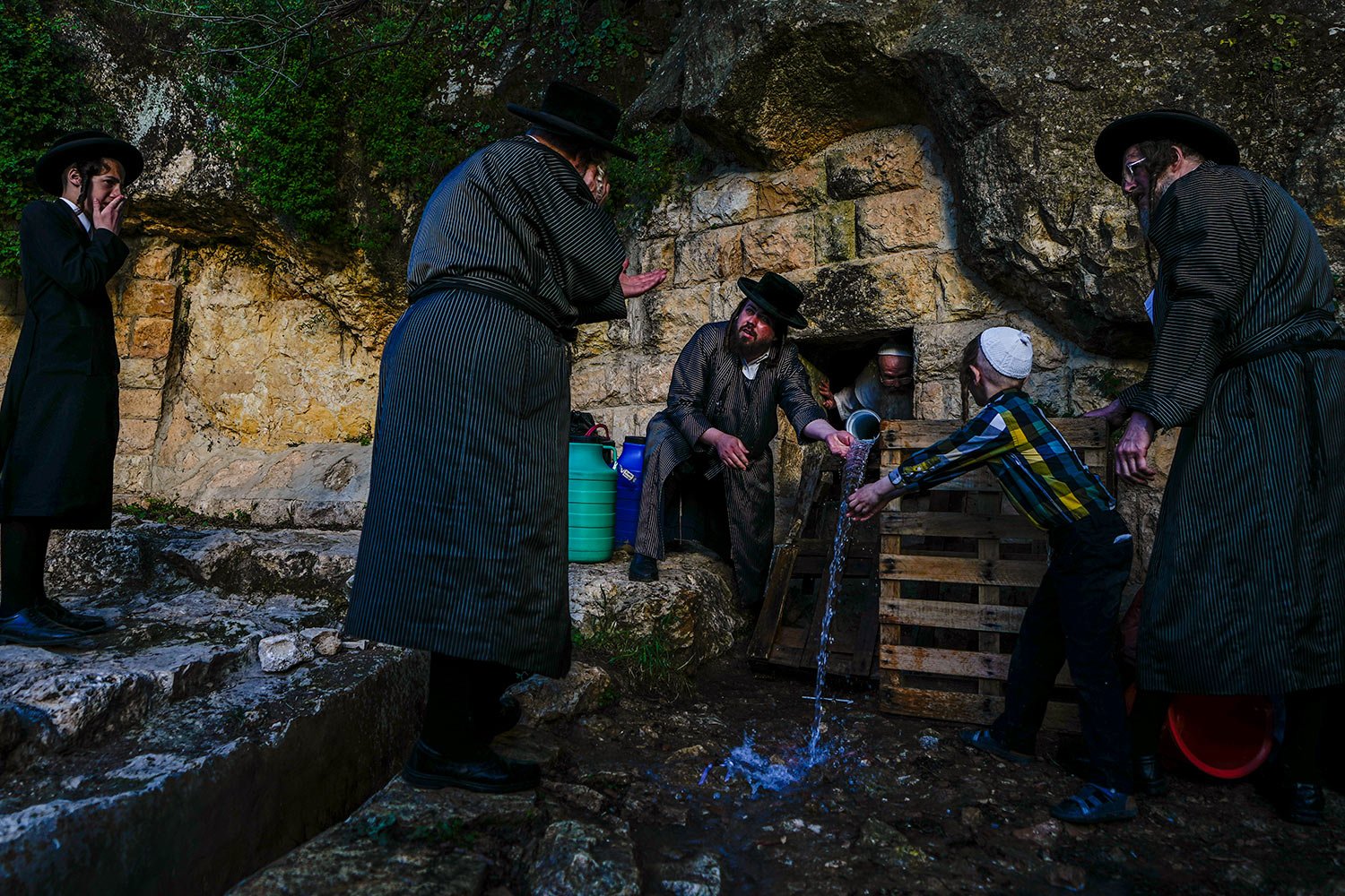  Ultra-Orthodox Jews collect water from a spring to make matzoh, a traditional handmade unleavened bread for Passover, during the Maim Shelanu ceremony at a mountain spring in the outskirts of Jerusalem, Tuesday, April 4, 2023. (AP Photo/Ariel Schali