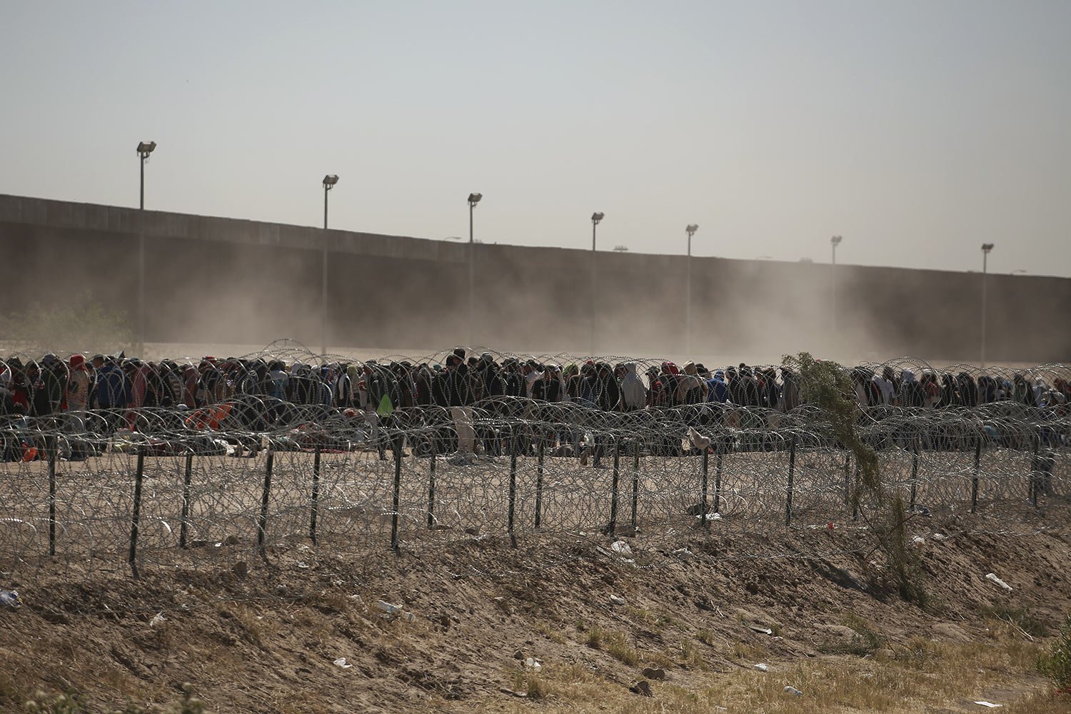  Migrants line-up between a barbed-wire barrier and the fence at the US-Mexico border, seen from Ciudad Juarez, Mexico, May 9, 2023. The U.S. ended on May 11 the Title 42 policy, linked to the coronavirus pandemic that allowed it to quickly expel mig
