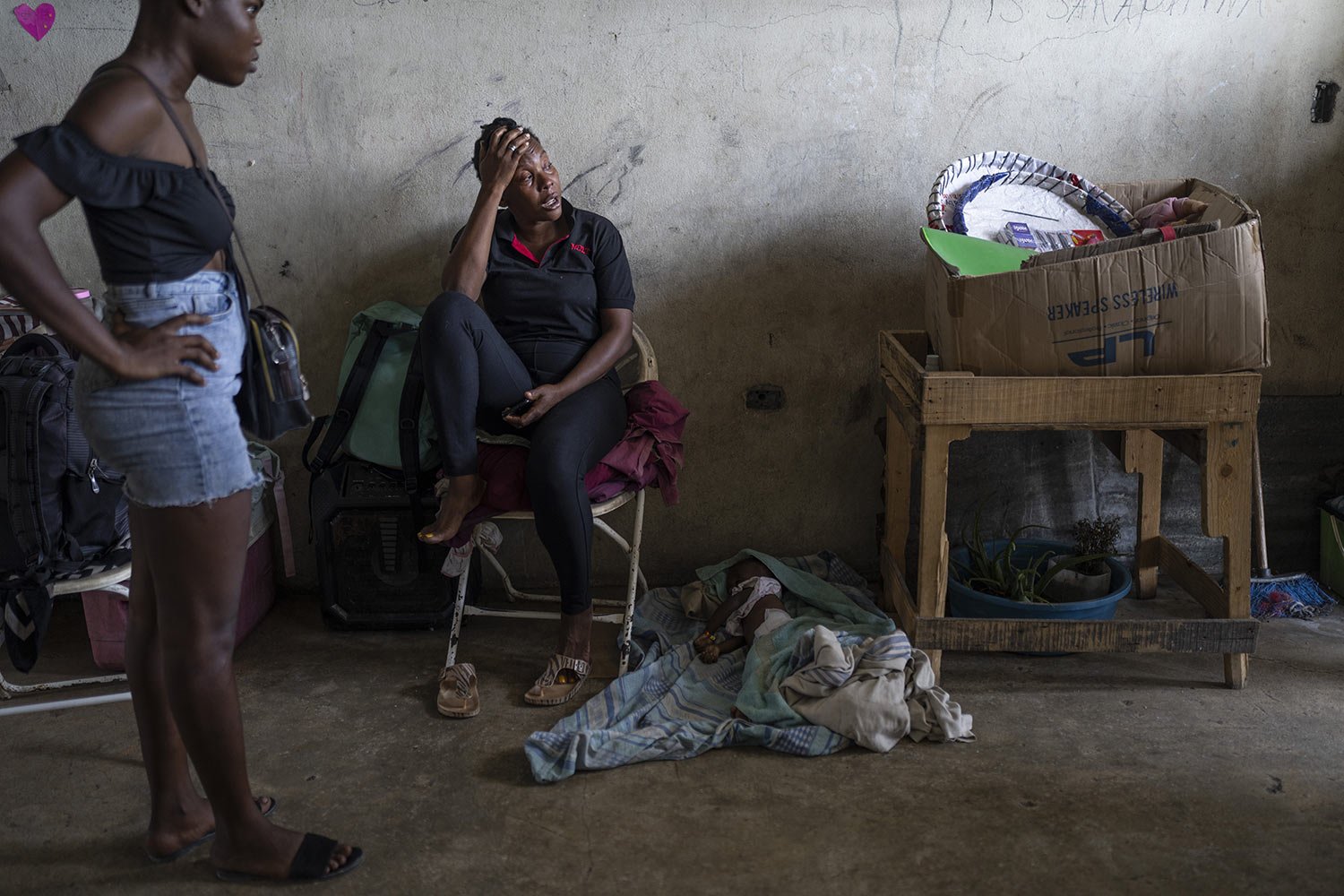  Elise Messadien cries as she sits next to the body of her one-year-old goddaughter, believed to have died of dehydration, at a shelter for people displaced by gang violence in Port-au-Prince, Haiti, May 30, 2023. (AP Photo/Ariana Cubillos) 