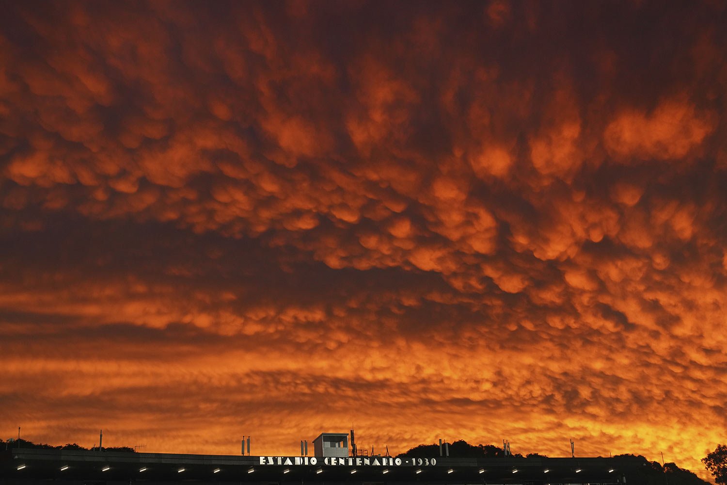  A red sky at dusk blankets Montevideo, Uruguay before the start of a Copa Libertadores soccer match at the Centenario stadium, May 24, 2023. (AP Photo/Matilde Campodonico) 