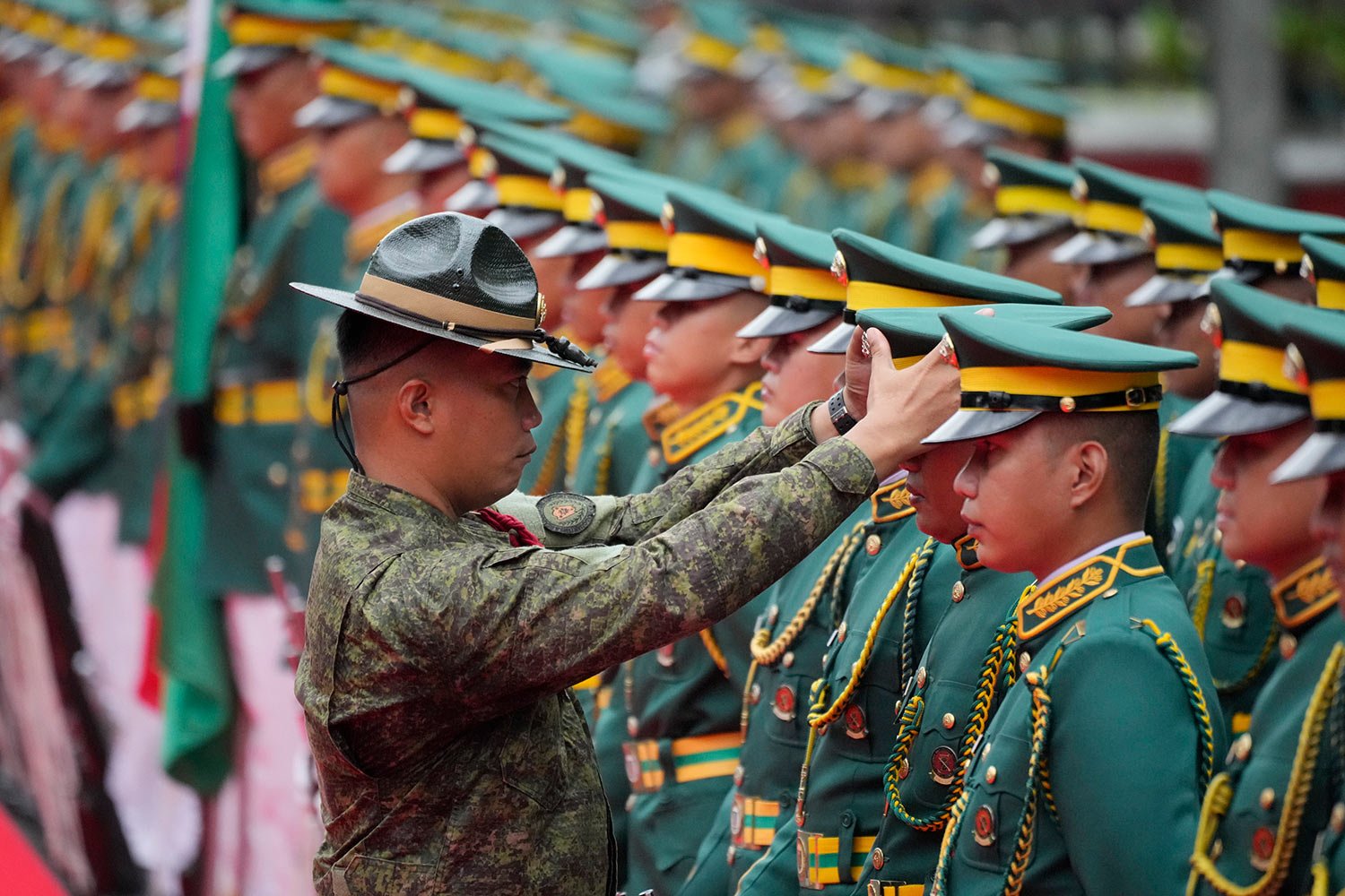  A Philippine Army officer checks on members of an honor guard before the start of arrival honors for United States Army Chief of Staff, General James McConville at Fort Bonifacio, Taguig city, Philippines on Wednesday, May 10, 2023. (AP Photo/Aaron 