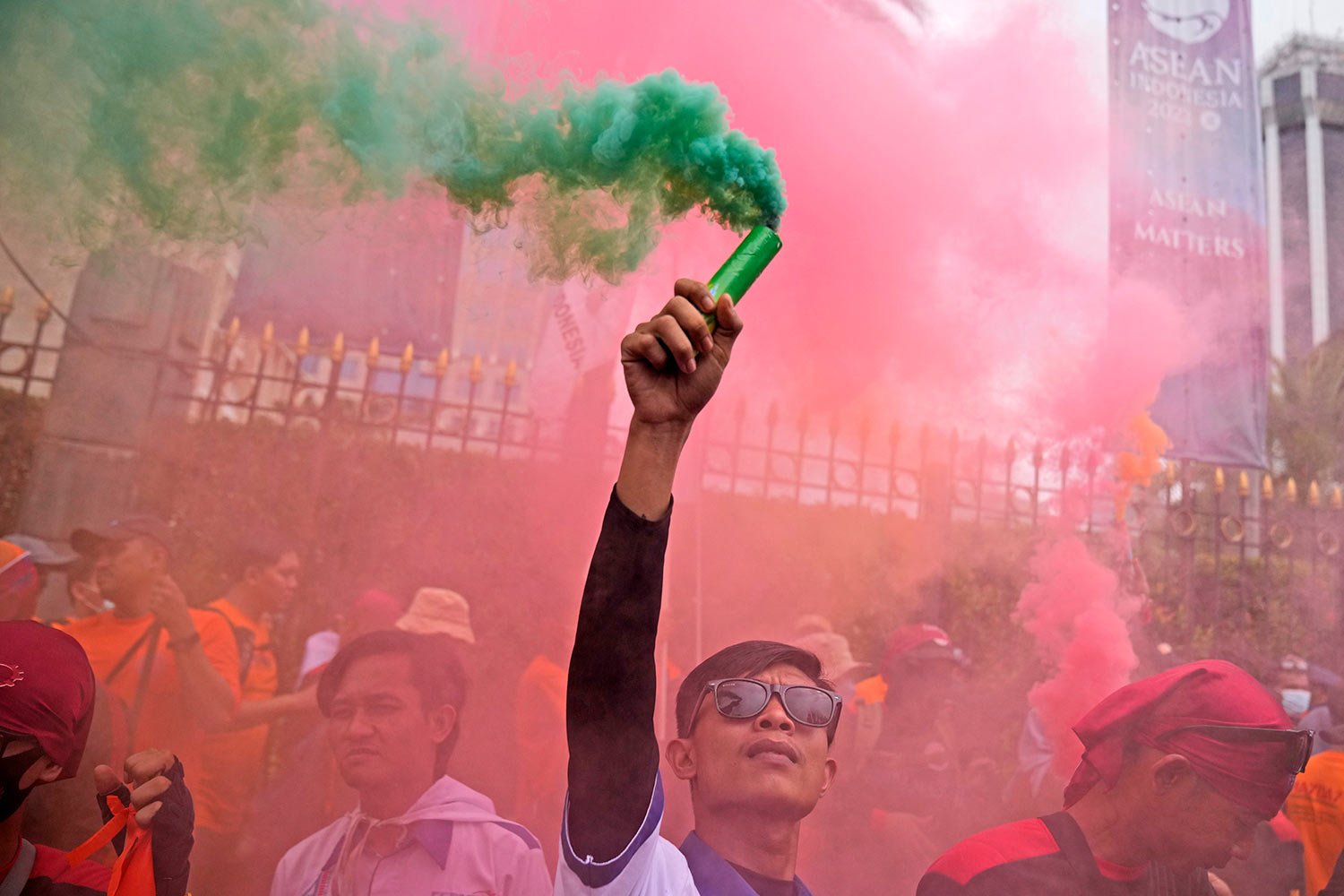  A worker holds up a smoke stick during a May Day rally in Jakarta, Indonesia, Monday, May 1, 2023. (AP Photo/Dita Alangkara) 