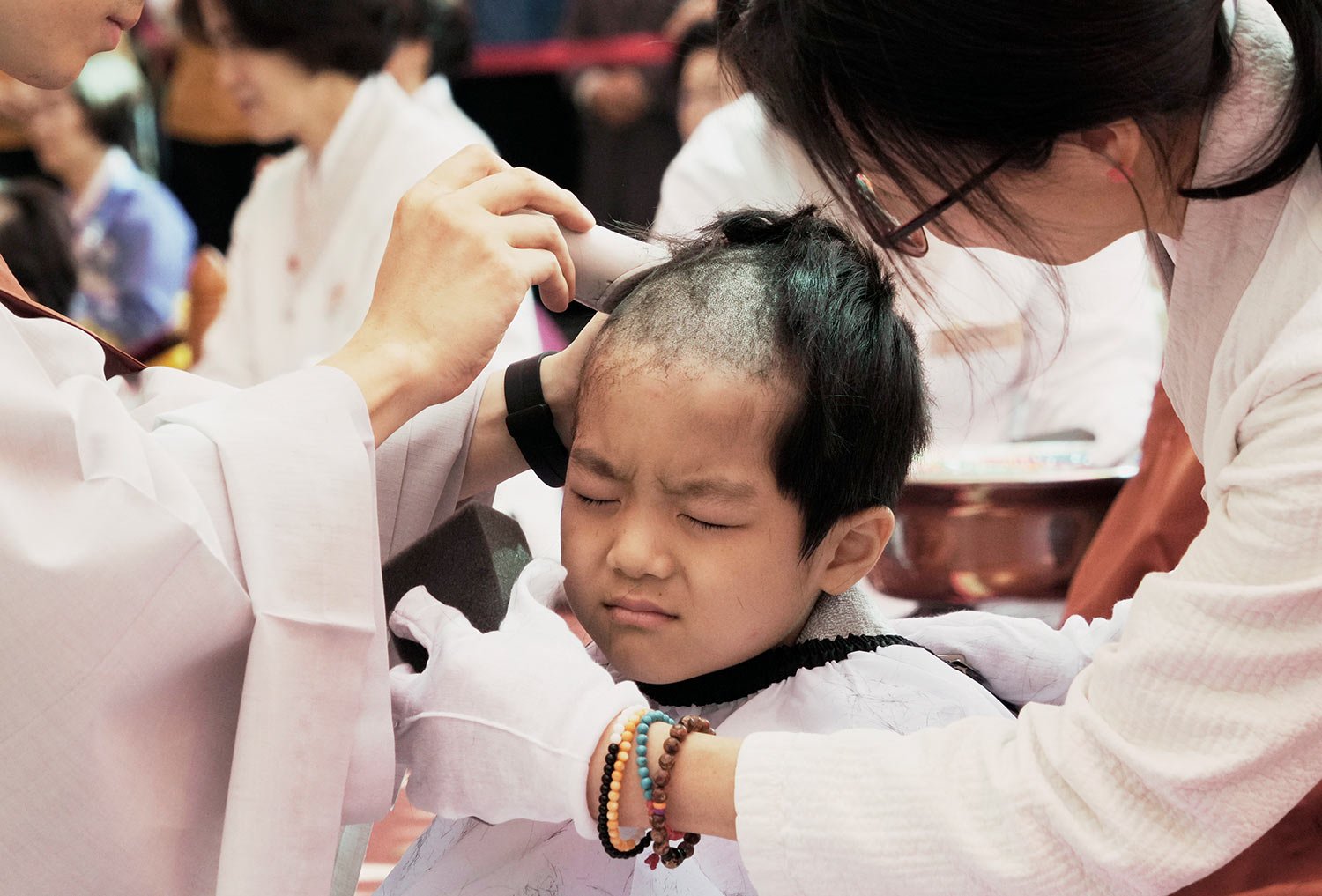  A boy reacts as a monk shaves his head during an event to have an experience of the lives of Buddhist monks, at the Jogye Temple in Seoul, South Korea, Tuesday, May 9, 2023. (AP Photo/Ahn Young-joon) 